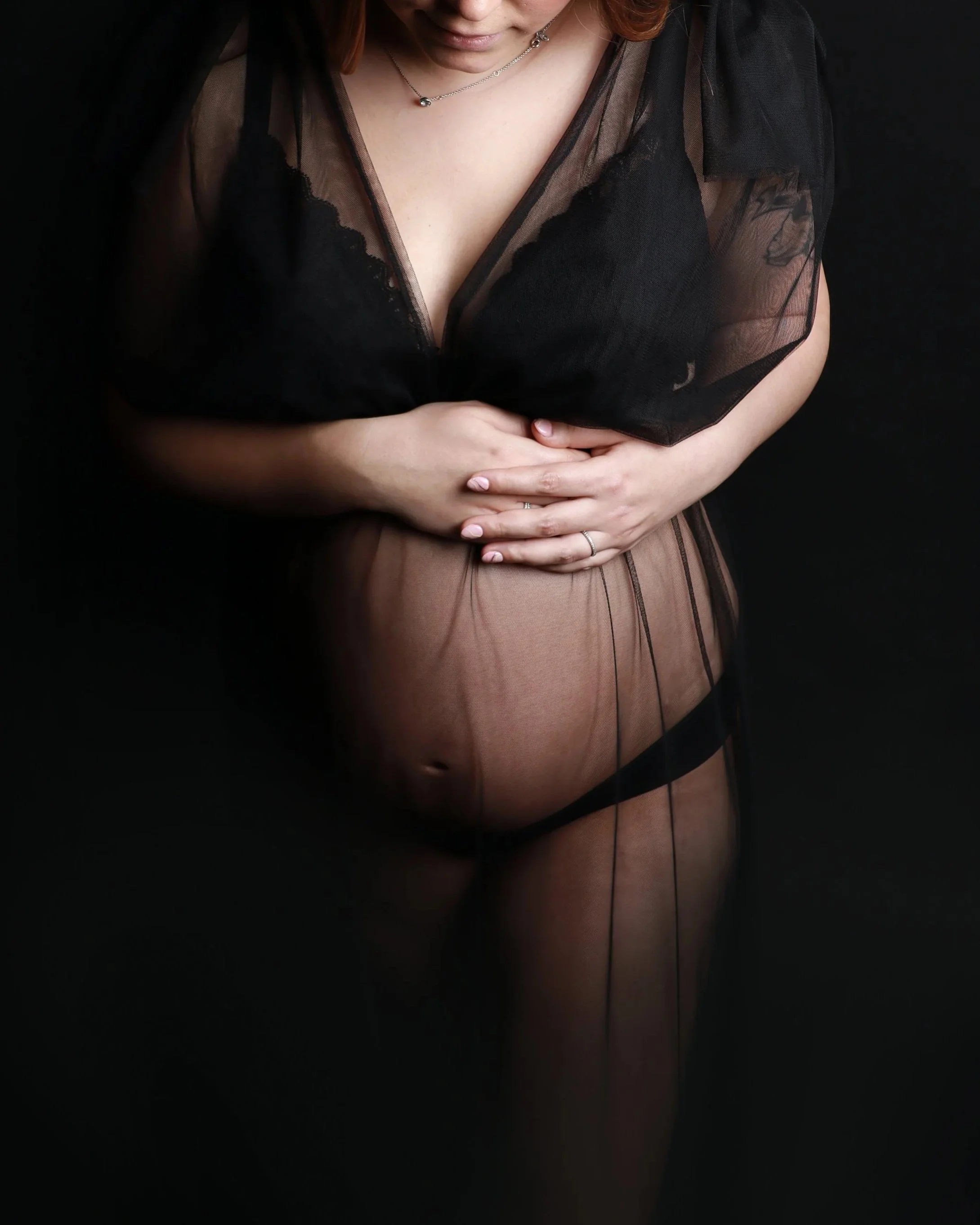 Femme enceinte qui tient son ventre dans une tenue noire
