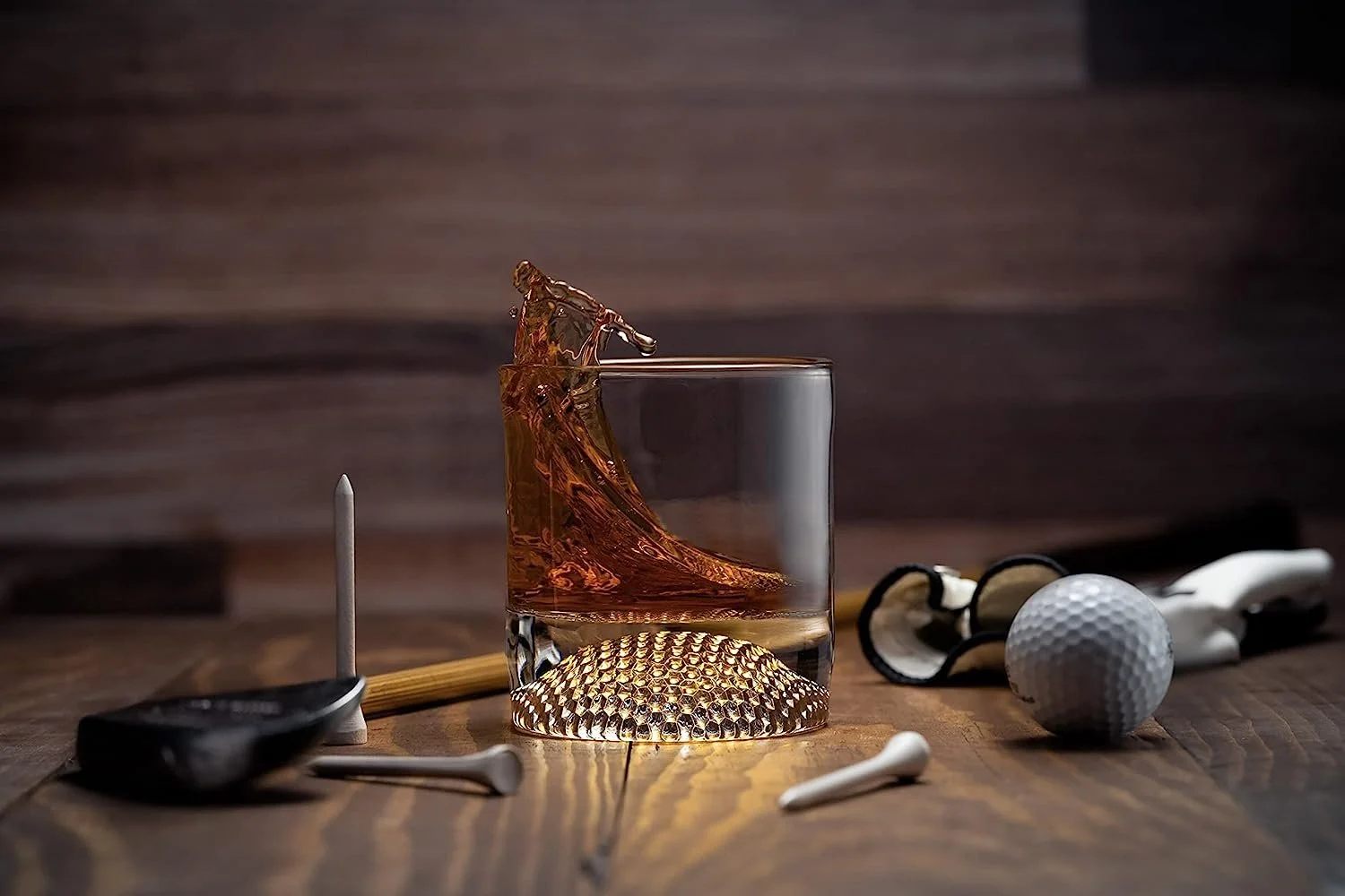 Golf ball whiskey glass filled with whiskey on a bar counter