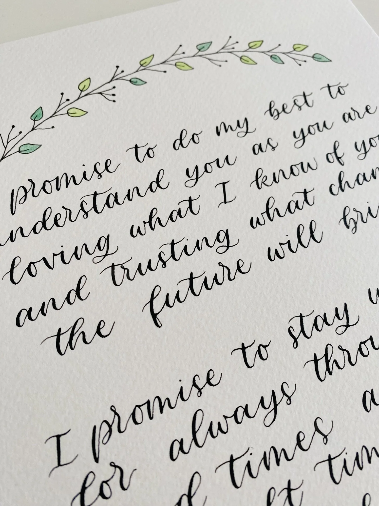 Close-up of handwritten text on white paper with decorative leaf illustrations at the top.