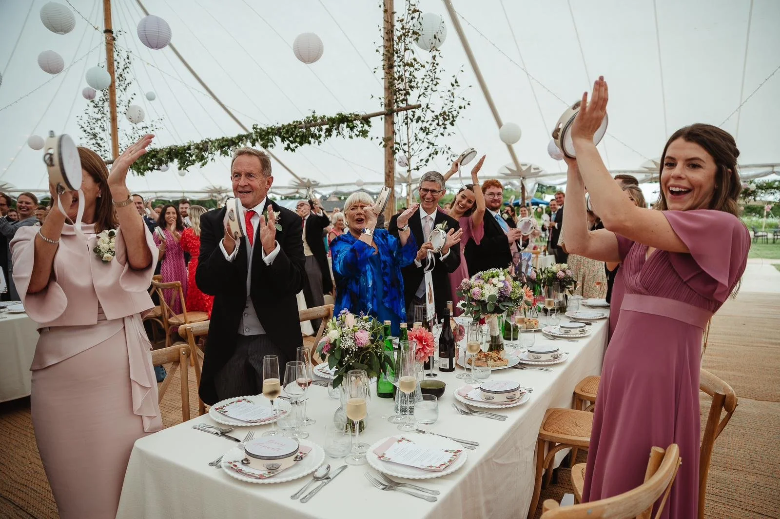 Wedding guests playing tambourines with their names written in calligraphy