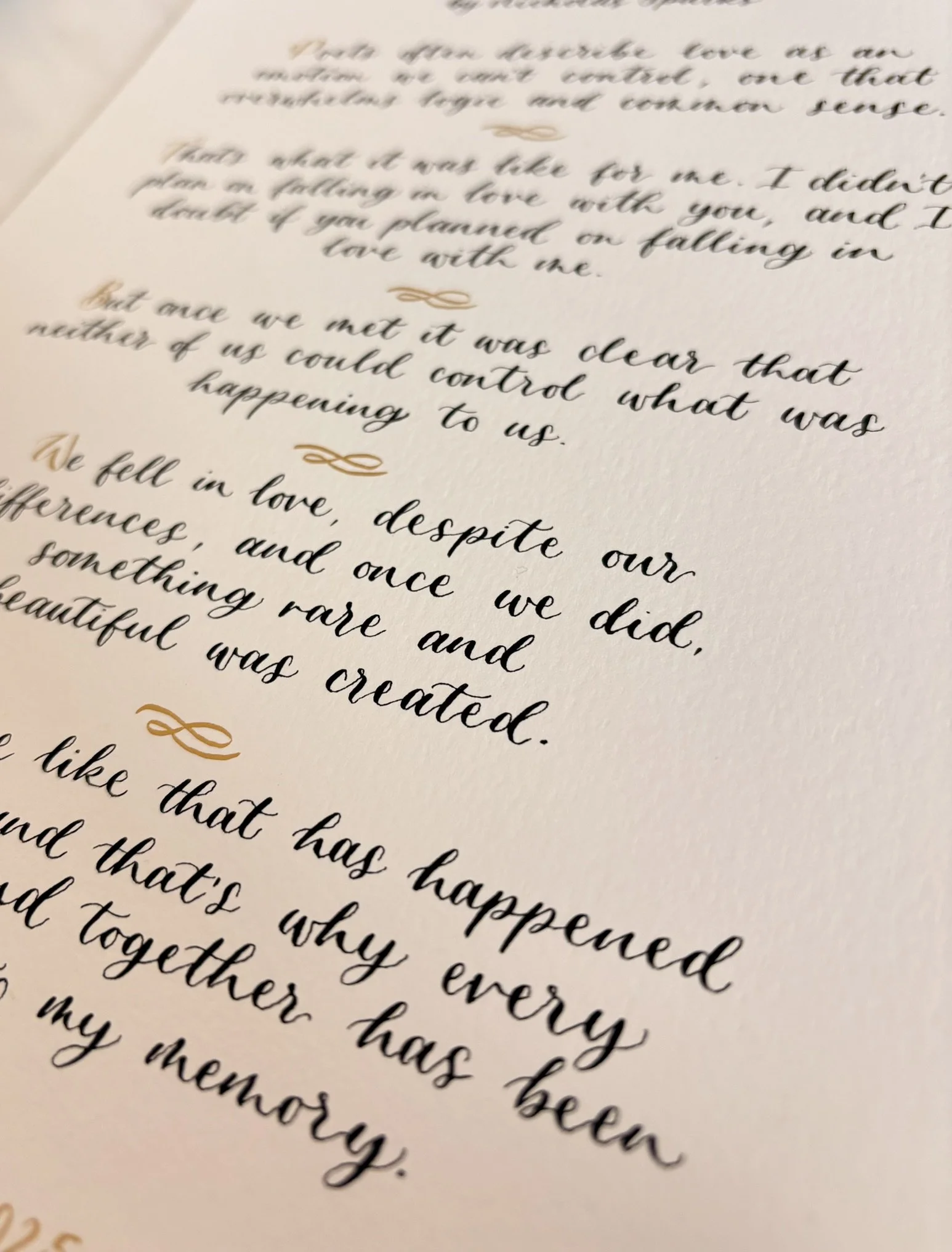 A sheet of paper with handwritten cursive text about love and special moments, decorated with small gold accents.