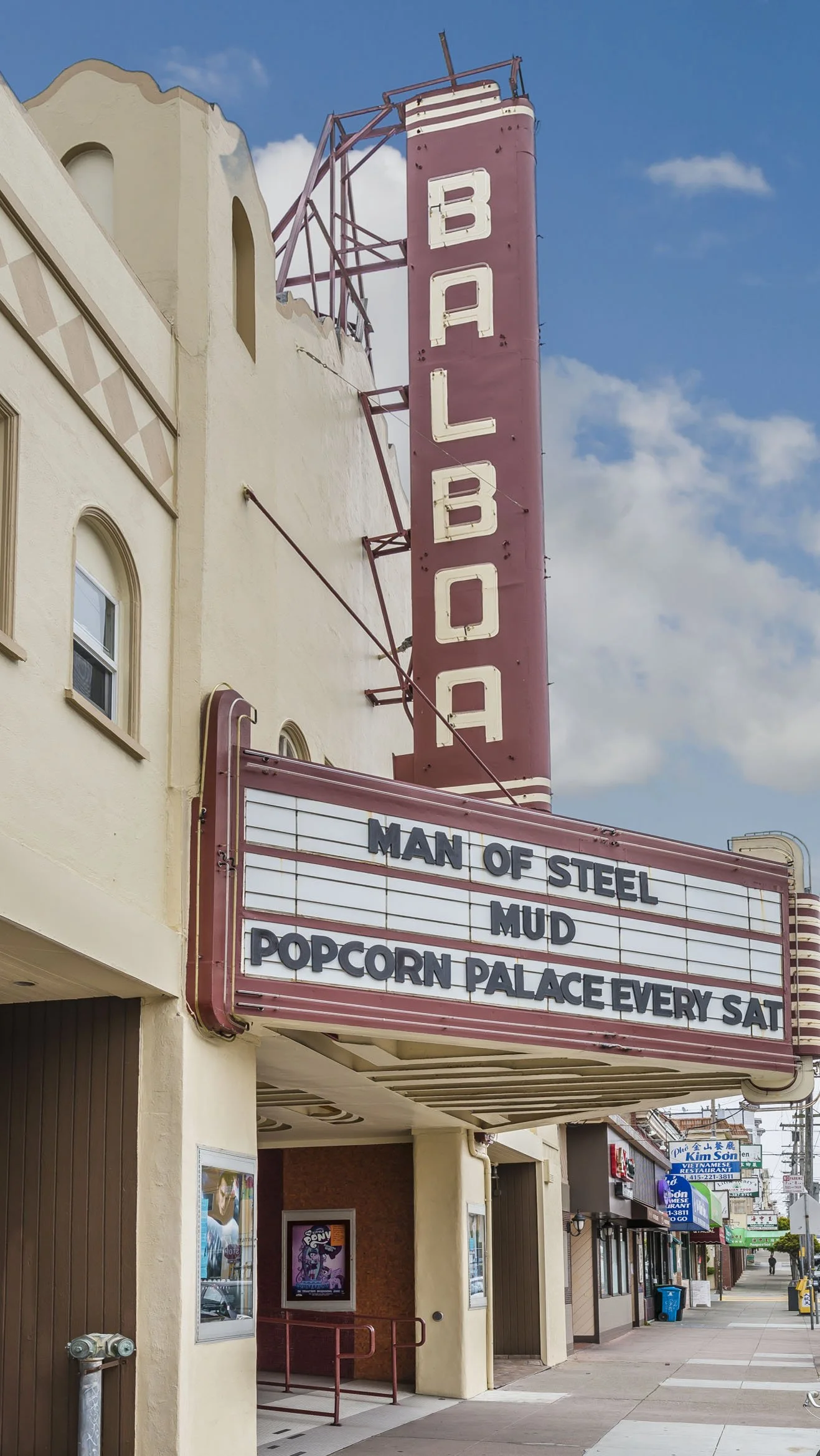 The Balboa theater marquee displays upcoming movie titles: 'Man of Steel,' 'Mud,' and 'Popcorn Palace Every Sat'.