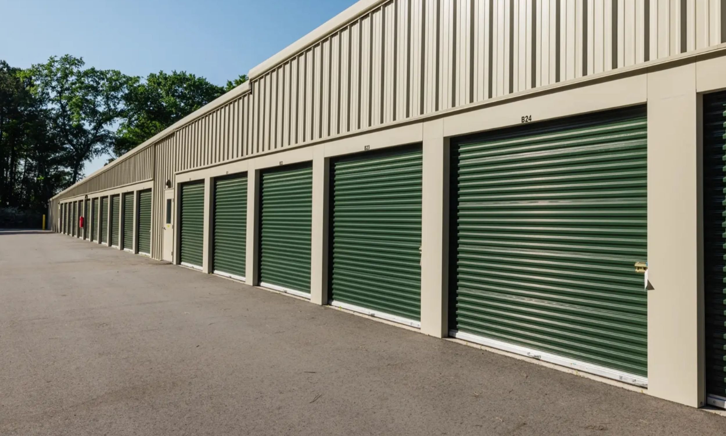 Drive-up storage units at Pinnacle Commercial Project in Wilmington NC designed by LAT34 Architecture with green roll-up doors and metal construction.