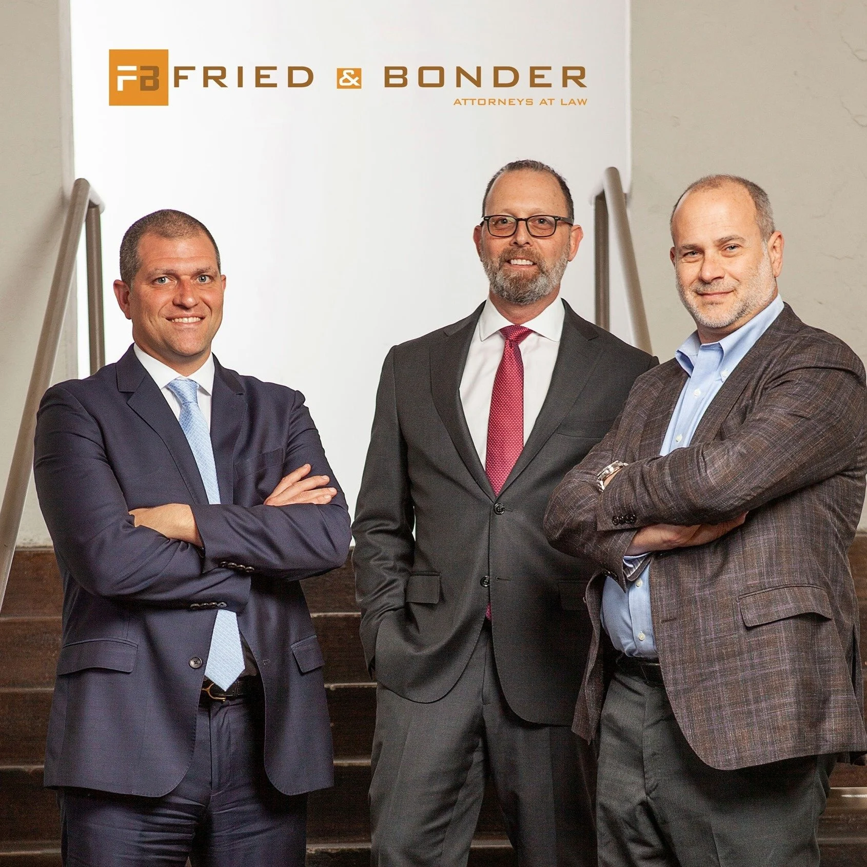 Three men in suits standing in front of a sign that reads 'Fried & Bonder Attorneys at Law'.