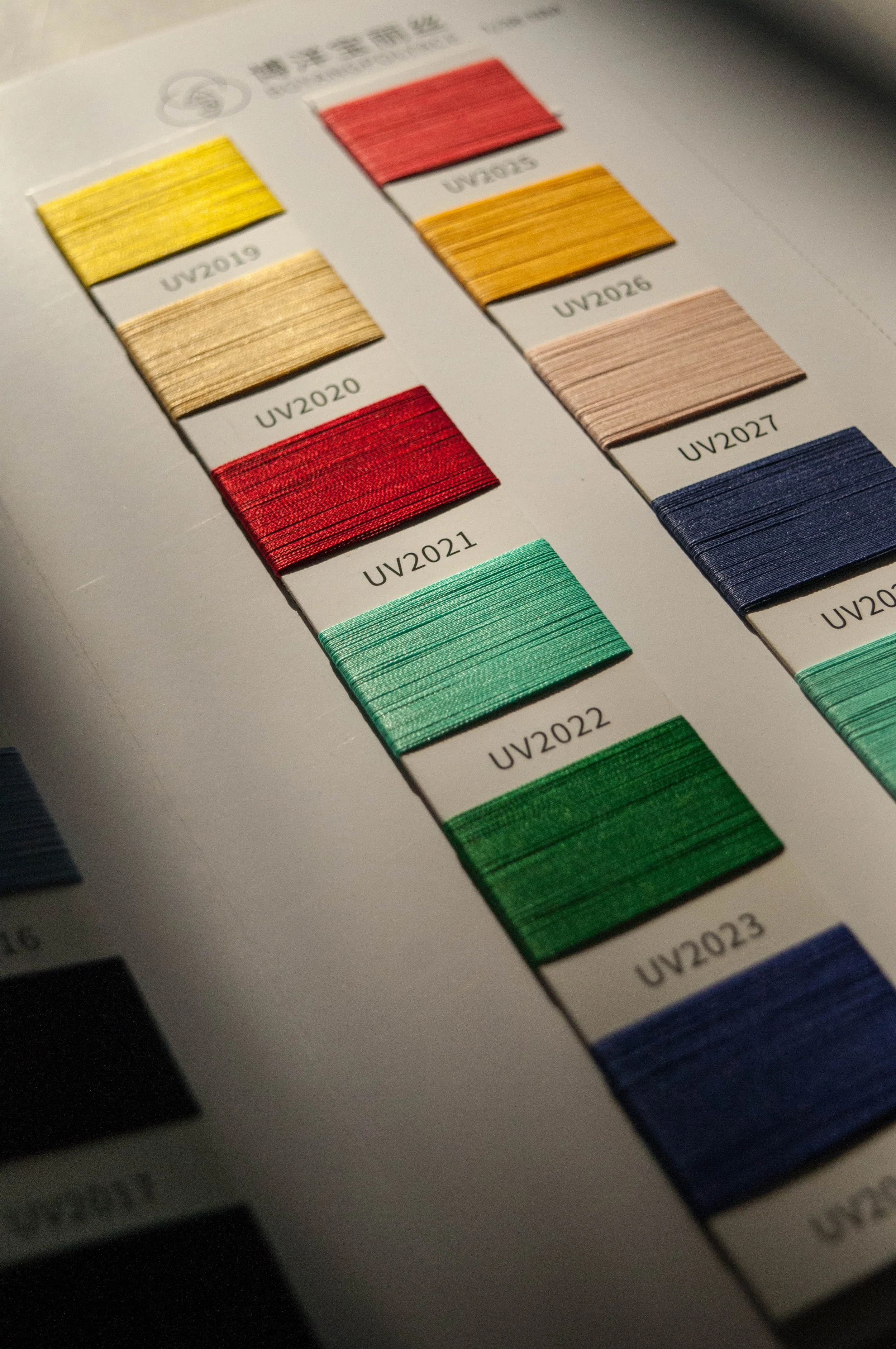 Mostruário de fios de cores diferentes com códigos de referência UV2020 a UV2023