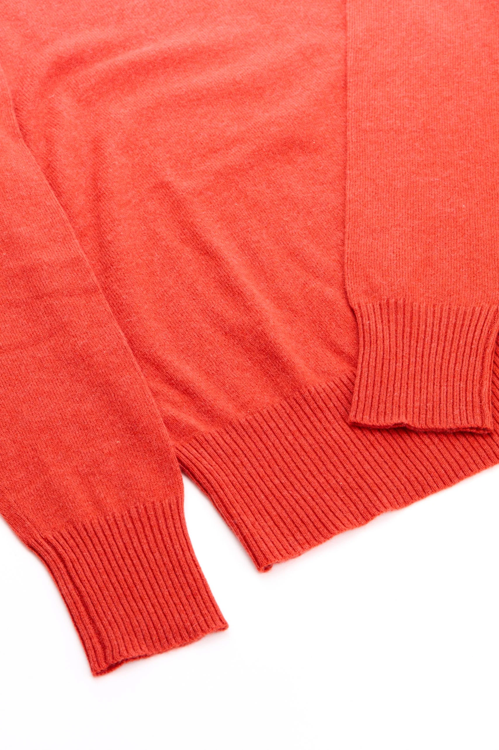 Detalhe de roupas de tricô vermelhas, com acabamento em ribana.