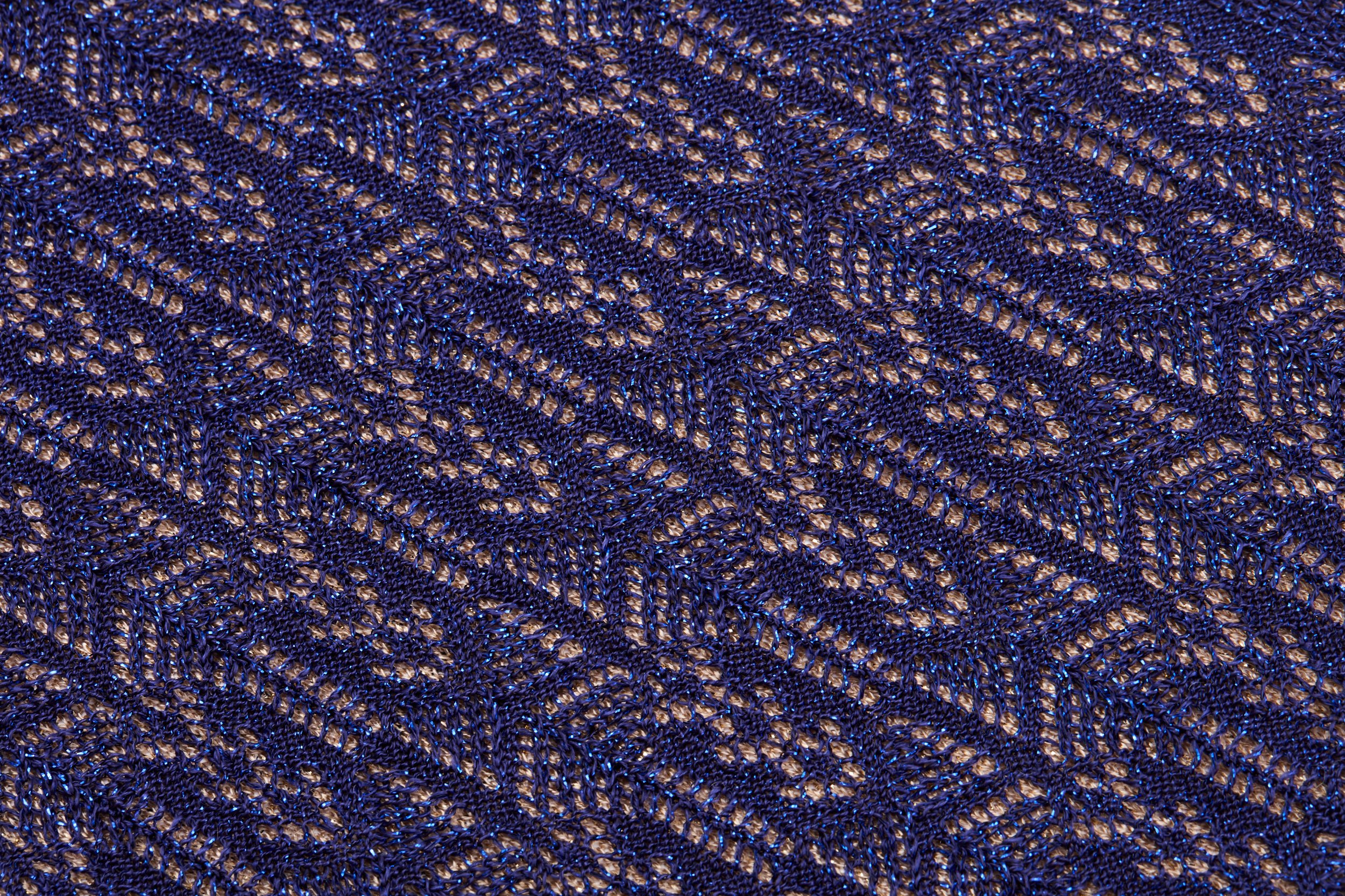 Tecido de renda azul com padrão de ondas e formas geométricas