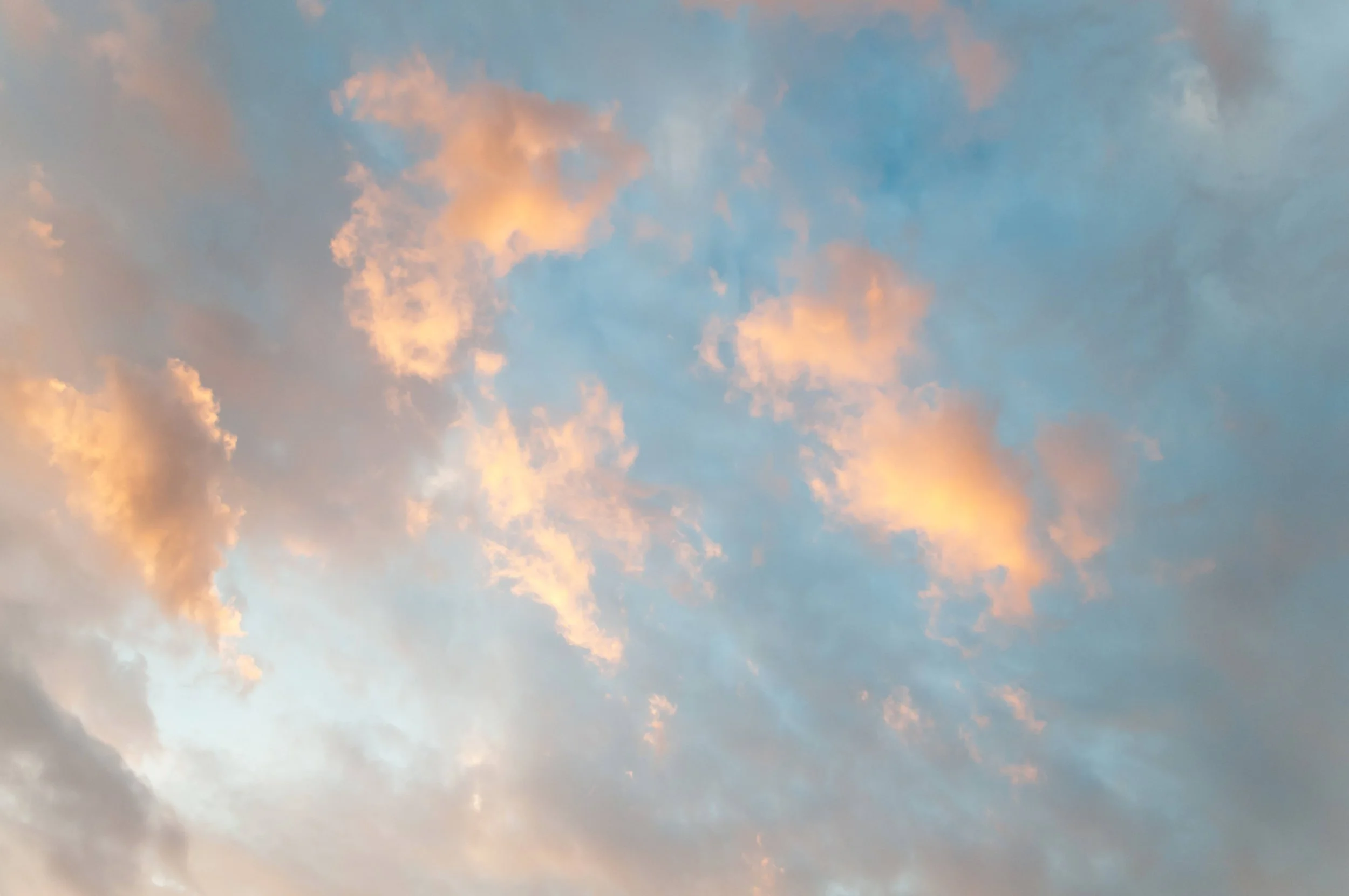 Sky with light blue and pinkish-orange clouds, possibly during sunset or sunrise.