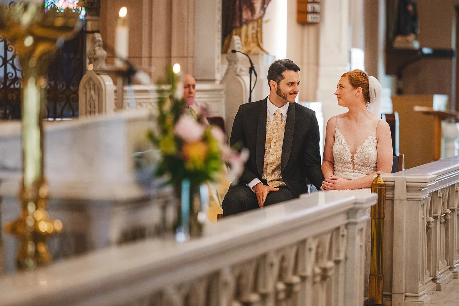 photo of a couple looking lovingly at each other during the ceremony in a catholic church