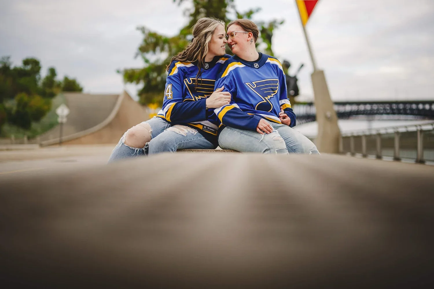Engagement portrait of a couple in matching jerseys sharing a joyful embrace and smiling during their photo session.