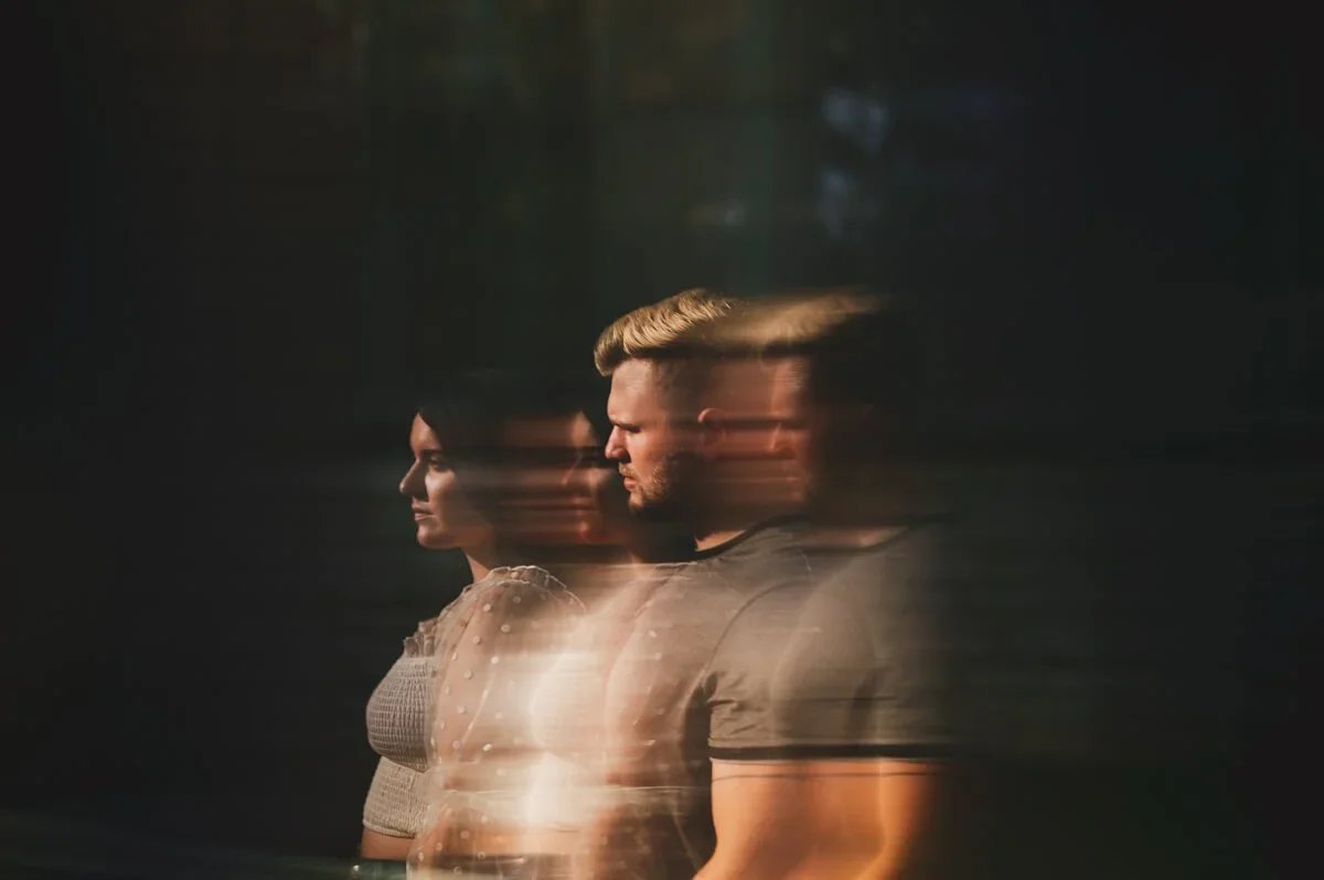 Creative engagement portrait featuring a couple layered in a multiple exposure effect against a black background.