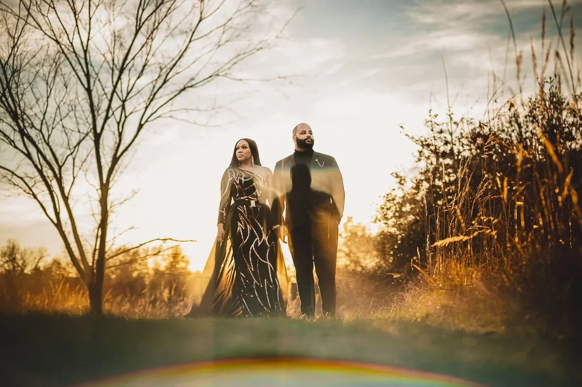Couple standing side by side during an engagement photoshoot in warm golden hour light.
