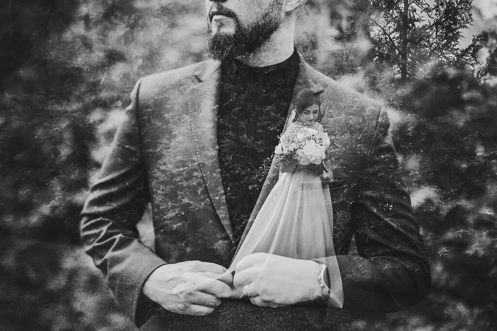 Black and white double exposure wedding portrait of a bride and groom wearing wedding attire on their wedding day.
