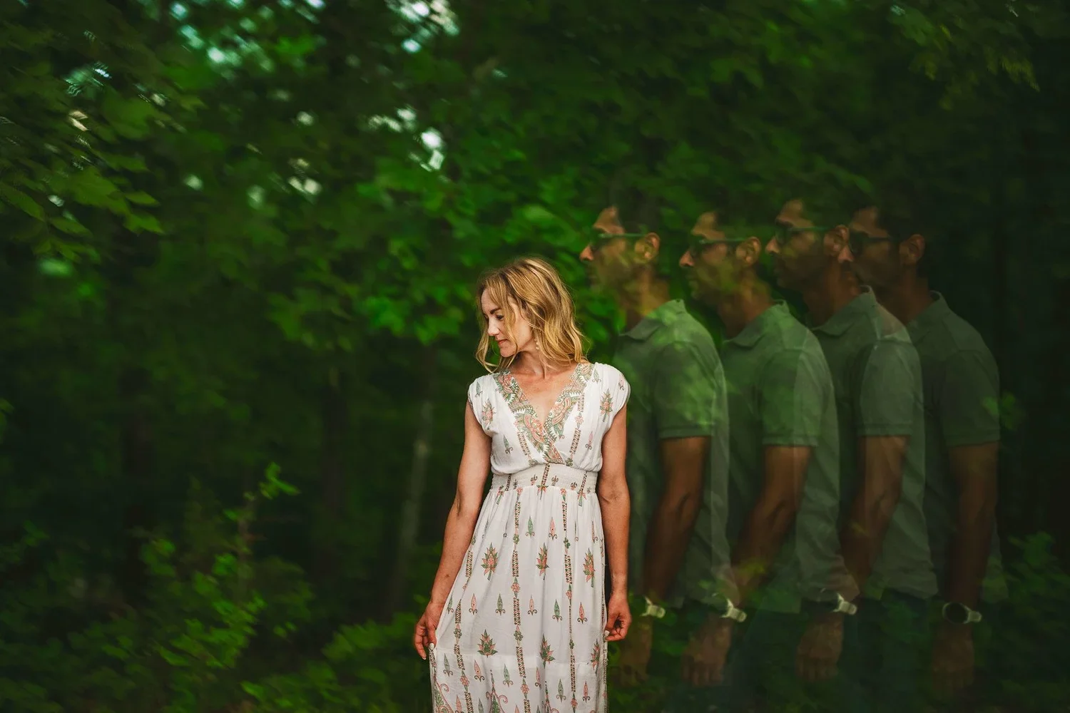 Artistic multiple exposure image of a couple surrounded by greenery, featuring a woman in a white dress and a man in a green shirt.