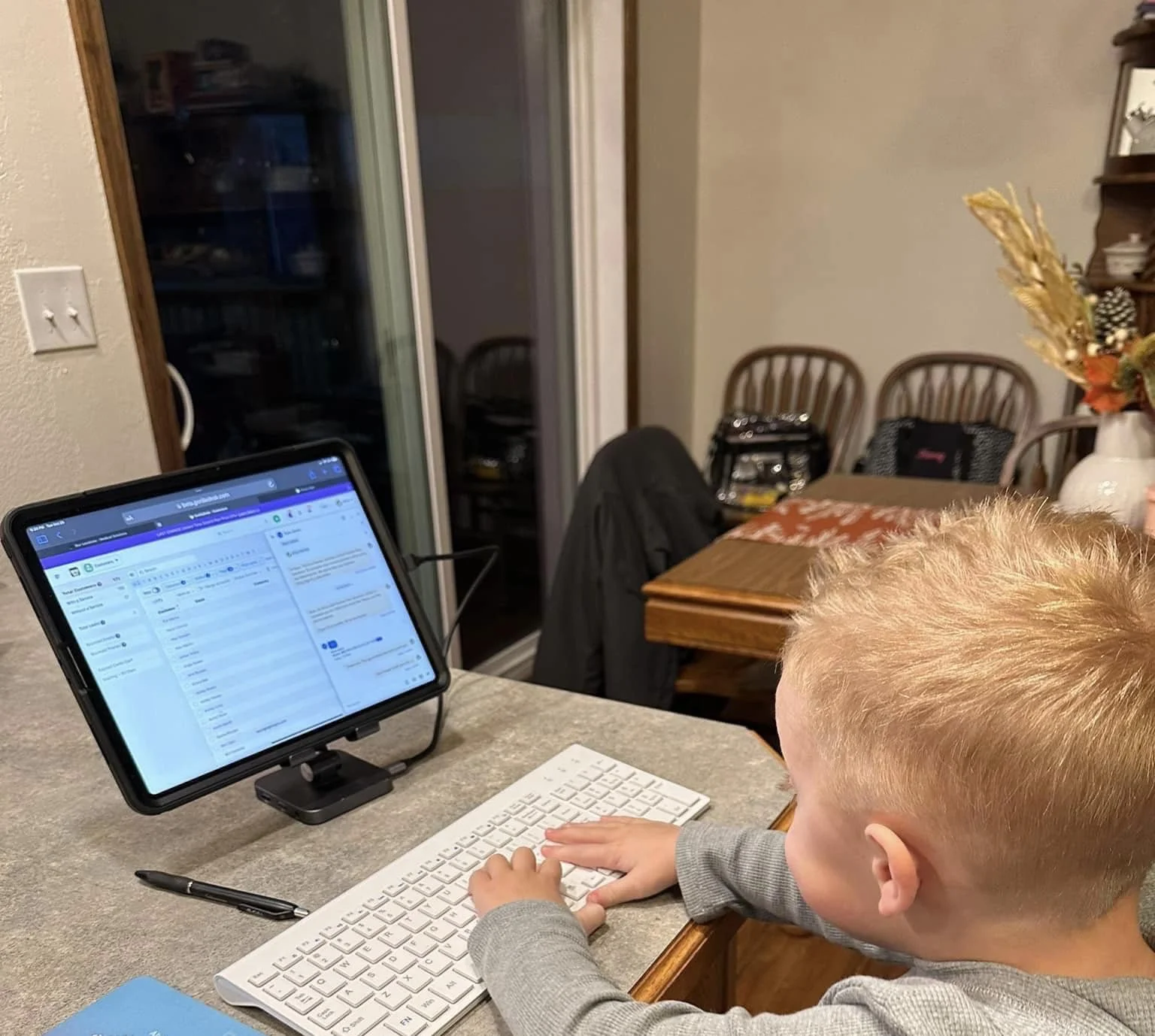 A young child, Brice's son, pretending to be hard at work in the Premier Pest Solutions office.