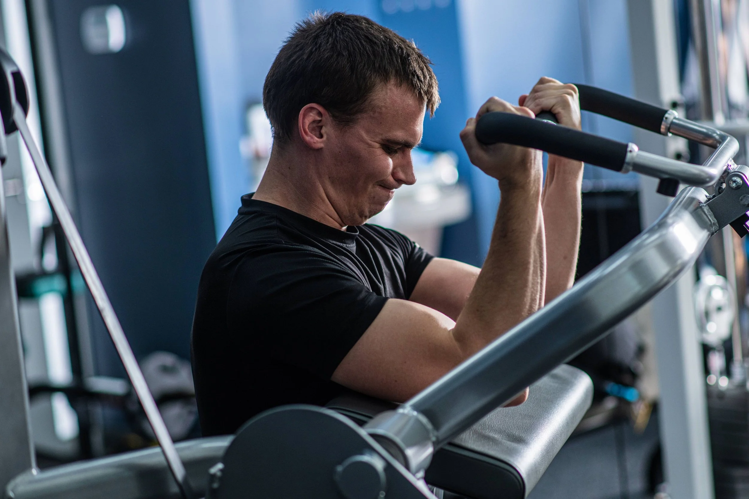 Man exercising on a rowing machine at a gym.