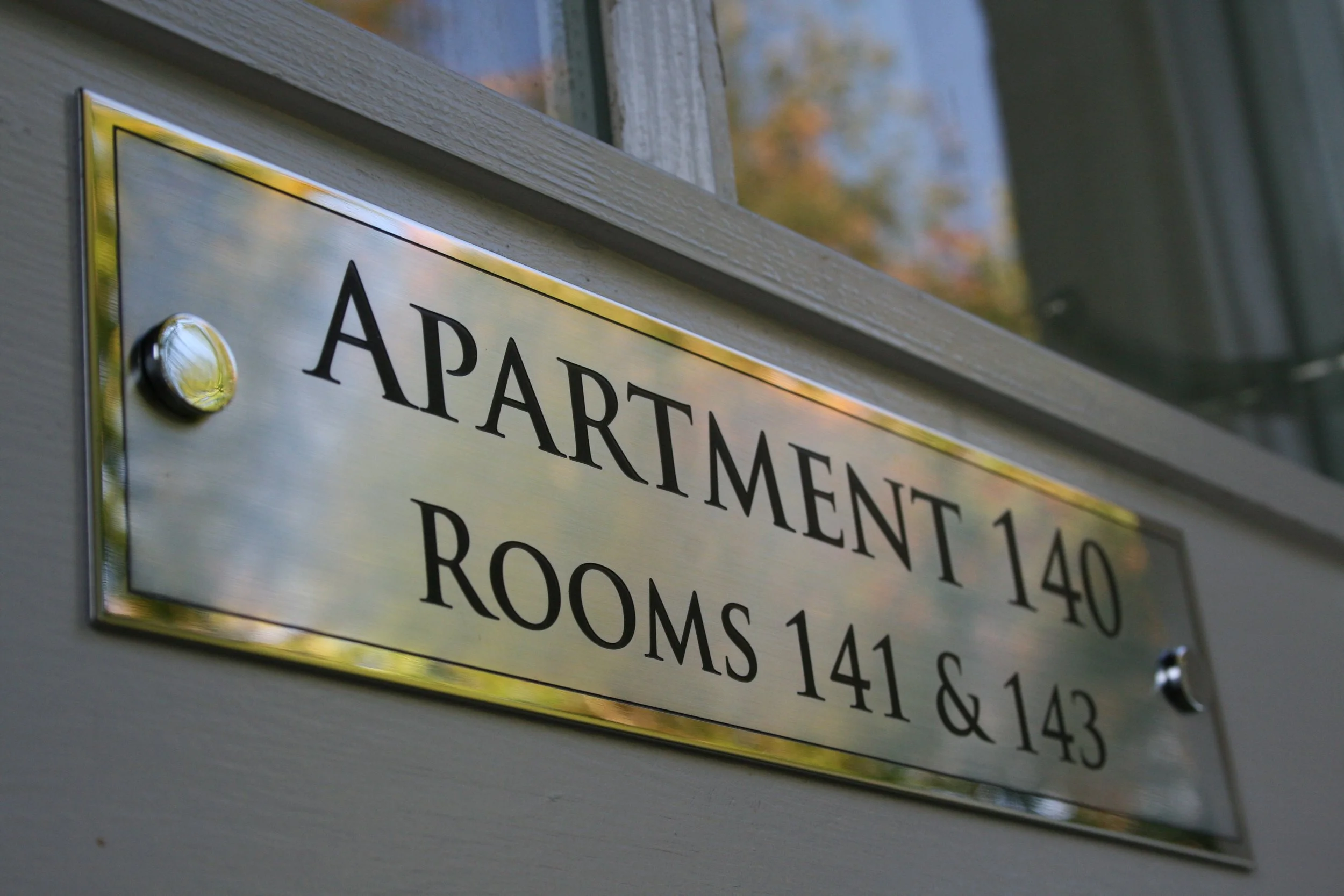 Close-up of a metallic building directory sign listing room numbers.