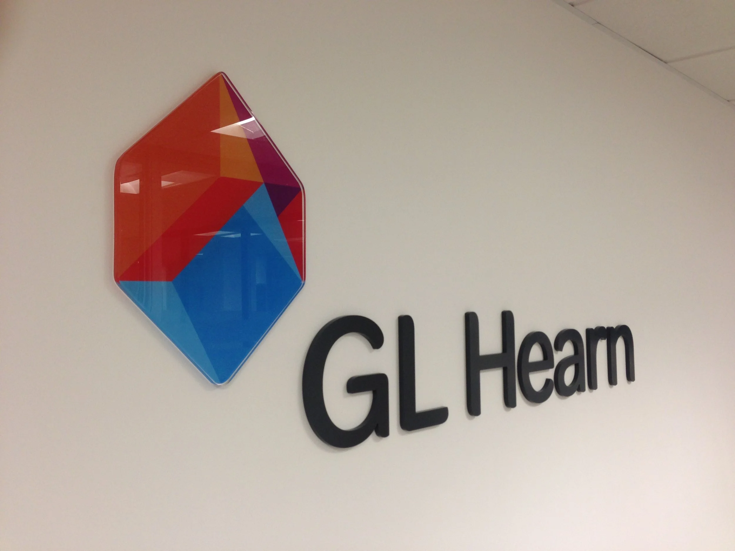 Colorful geometric logo on a light background with part of a word visible below.