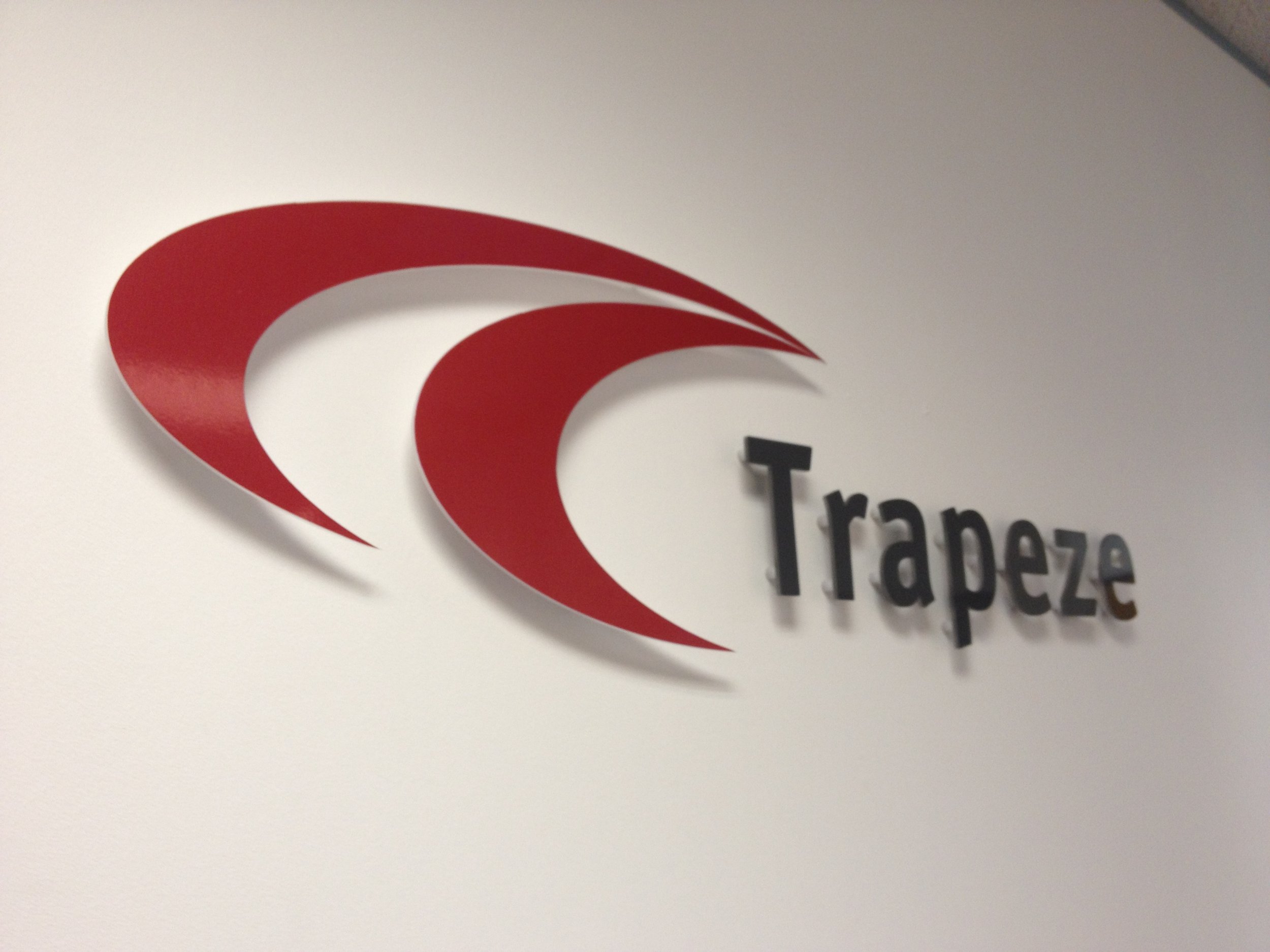 Close-up of a company logo with a stylized red swirl and black text reading 'Transaer.'