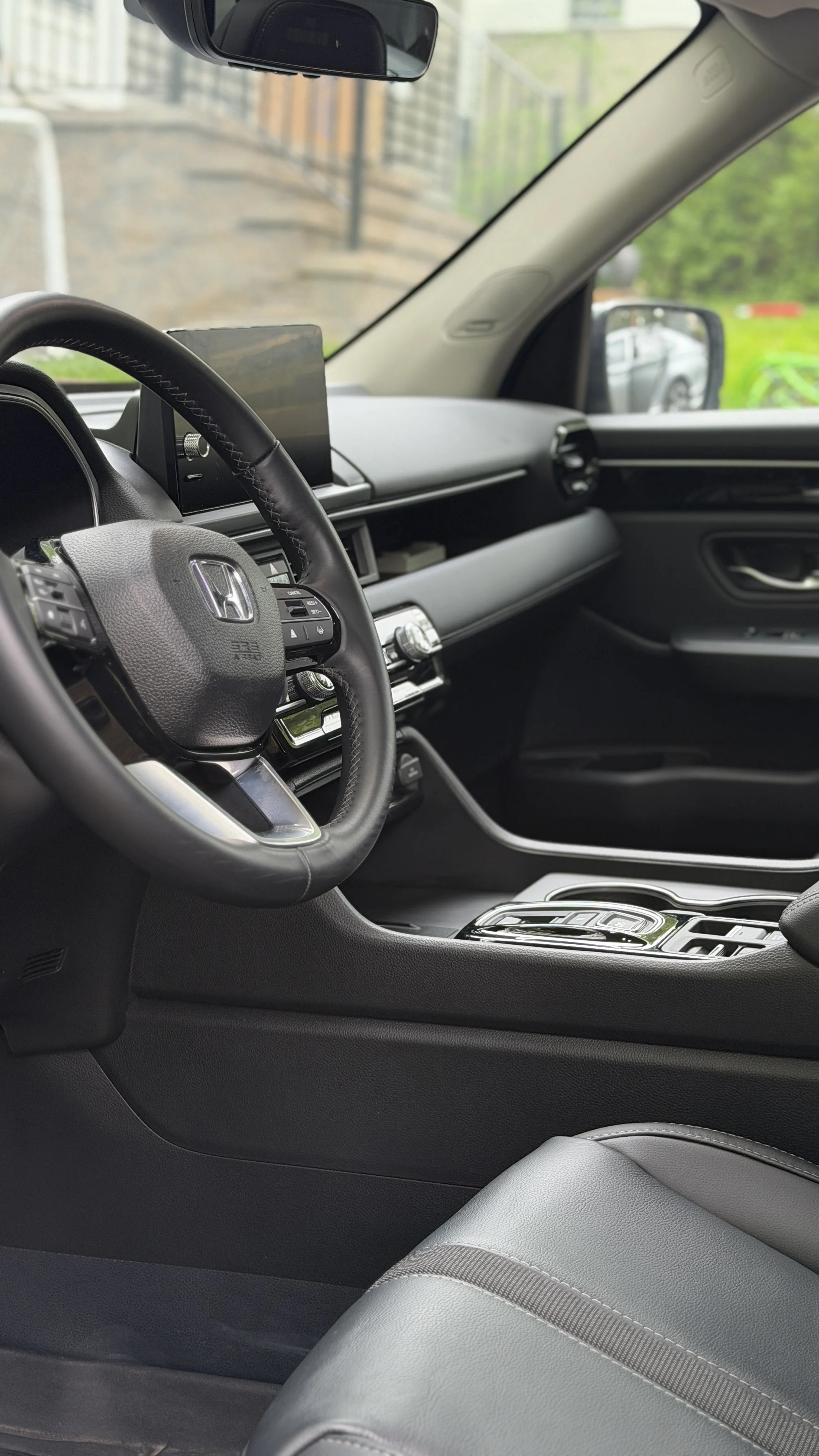 Interior of a modern car showing the steering wheel, dashboard, and front passenger seat.