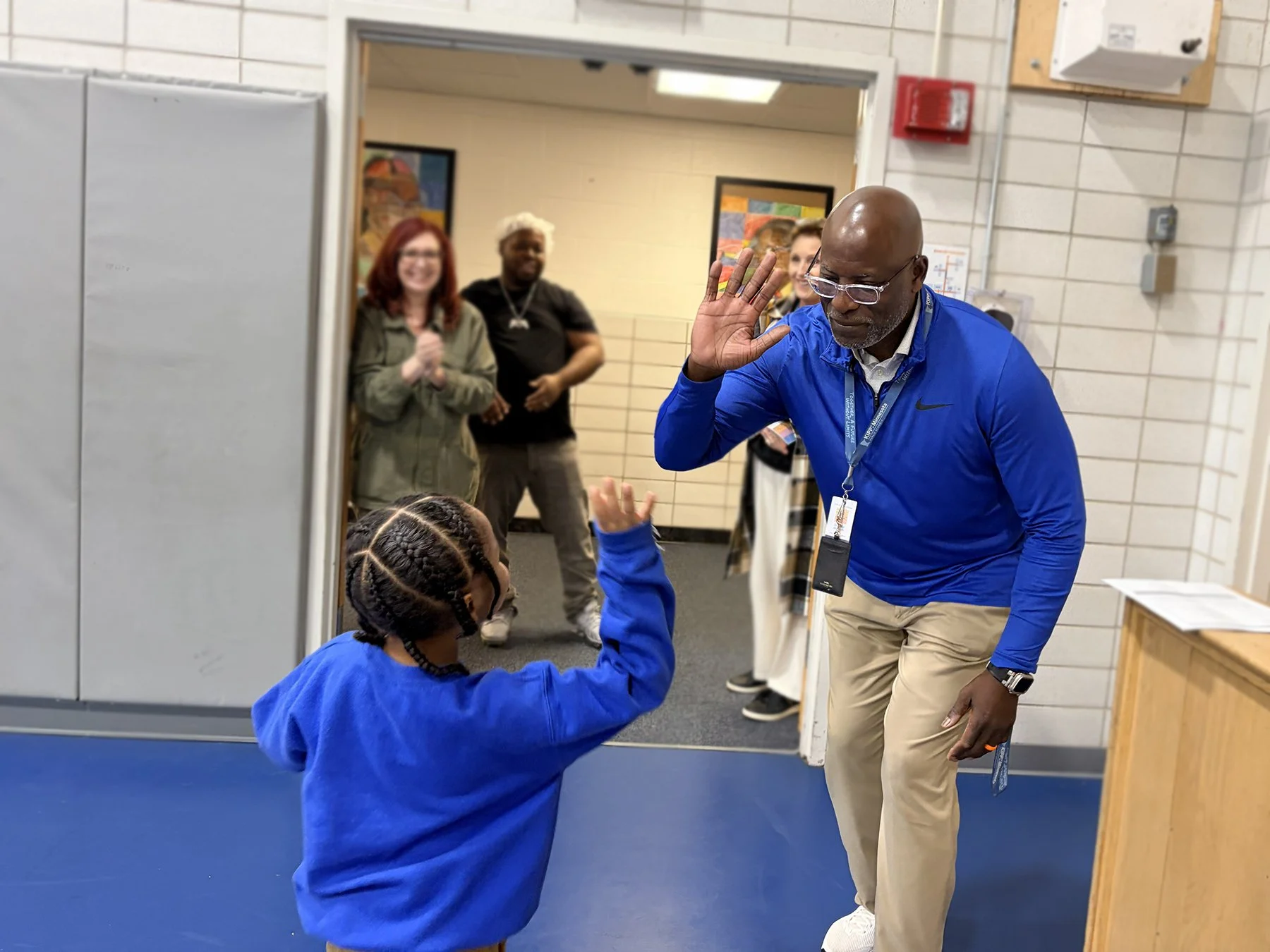 Our Chief Academic Officer, Dr. Isreal Moses highfiving a student during our Student Recognition Assembly