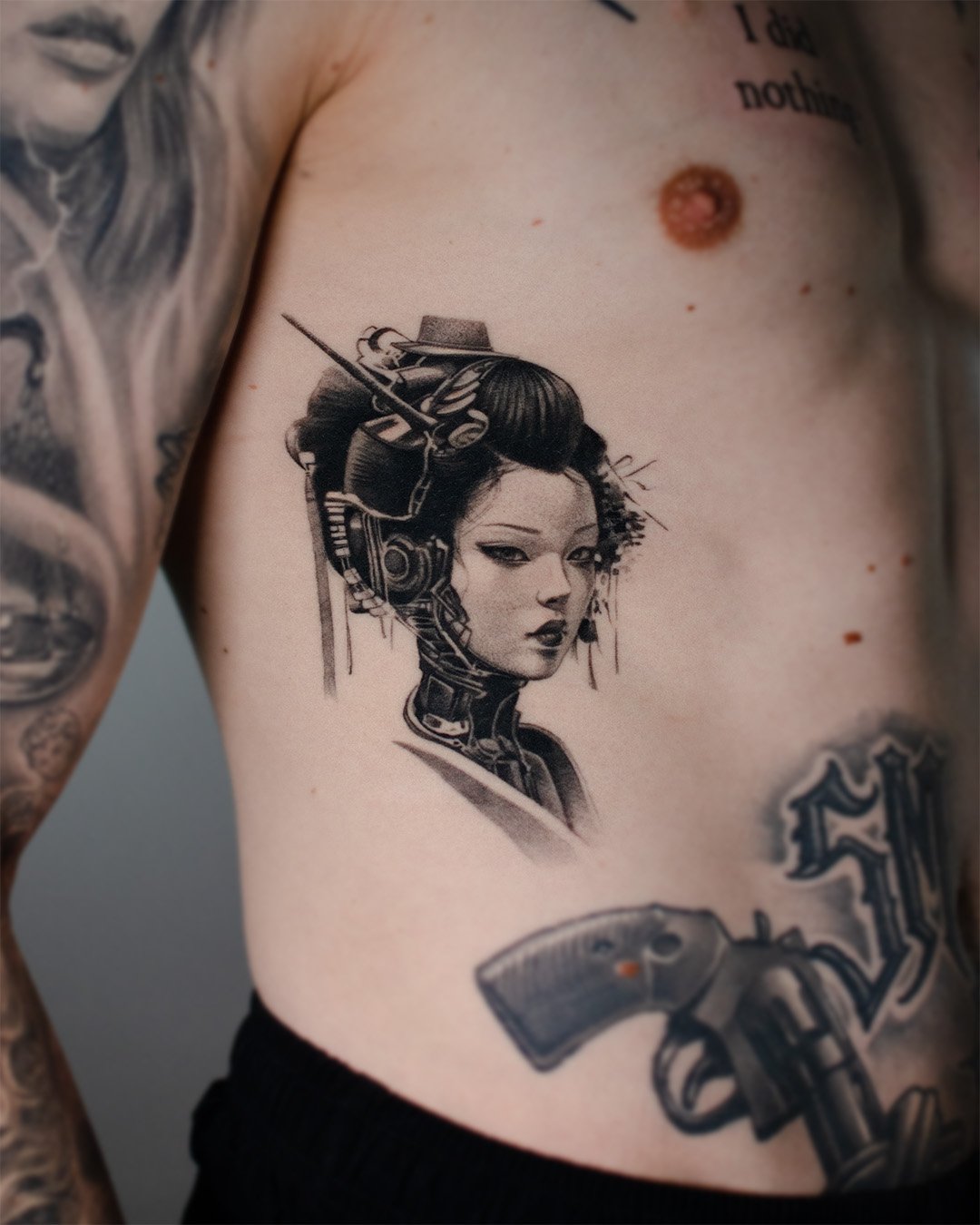 Tattoo of a futuristic woman with cybernetic enhancements and traditional hairstyle on person's side ribcage.