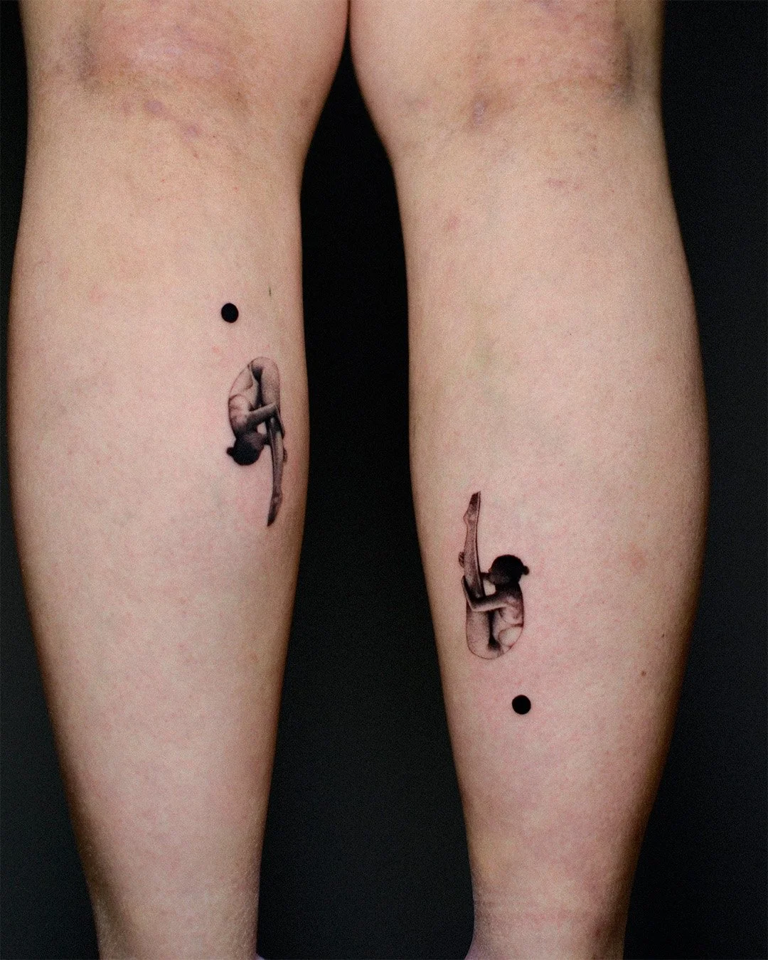 Tattoo of a woman in a swimsuit hanging upside down on each thigh with small black dots above and below.