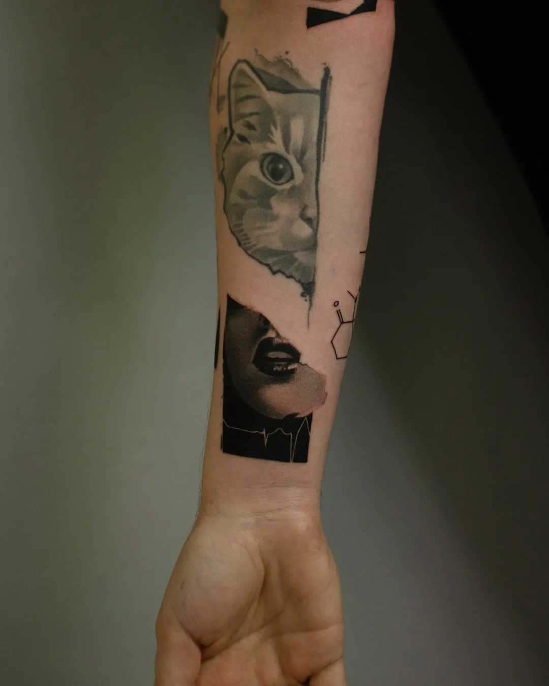 Tattoo of a cat's face peeking out of a window and a woman's face with closed eyes and dark makeup, alongside chemical structure lines.