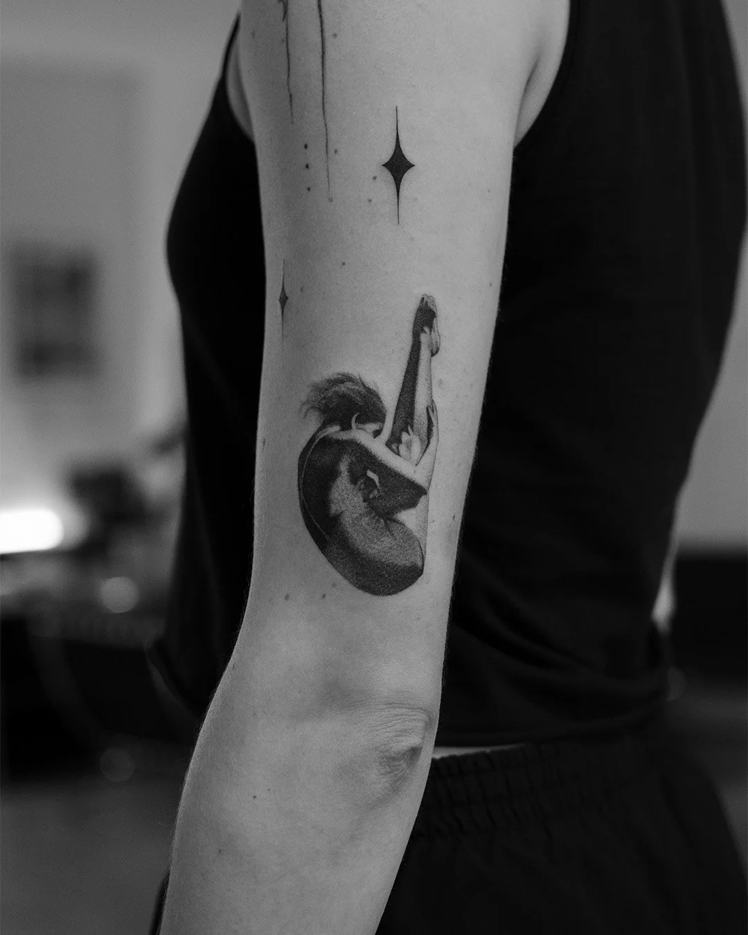 Black and white tattoo of a woman, diver tattoo, dot work in surrealistic style, star-shaped celestial designs above.