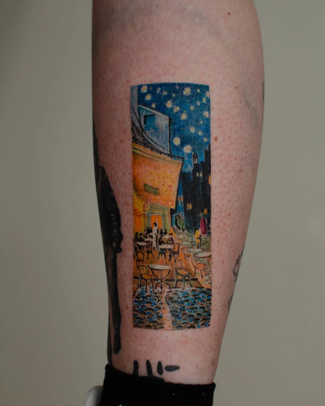 Tattoo of Van Gogh's Starry Night Over the Rhône in a vertical rectangle on a person's forearm.
