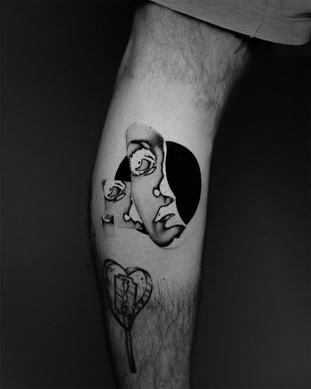 Black and white tattoo of a woman's face in profile within a circle, with two smaller cups and a heart with a syringe inside it below.