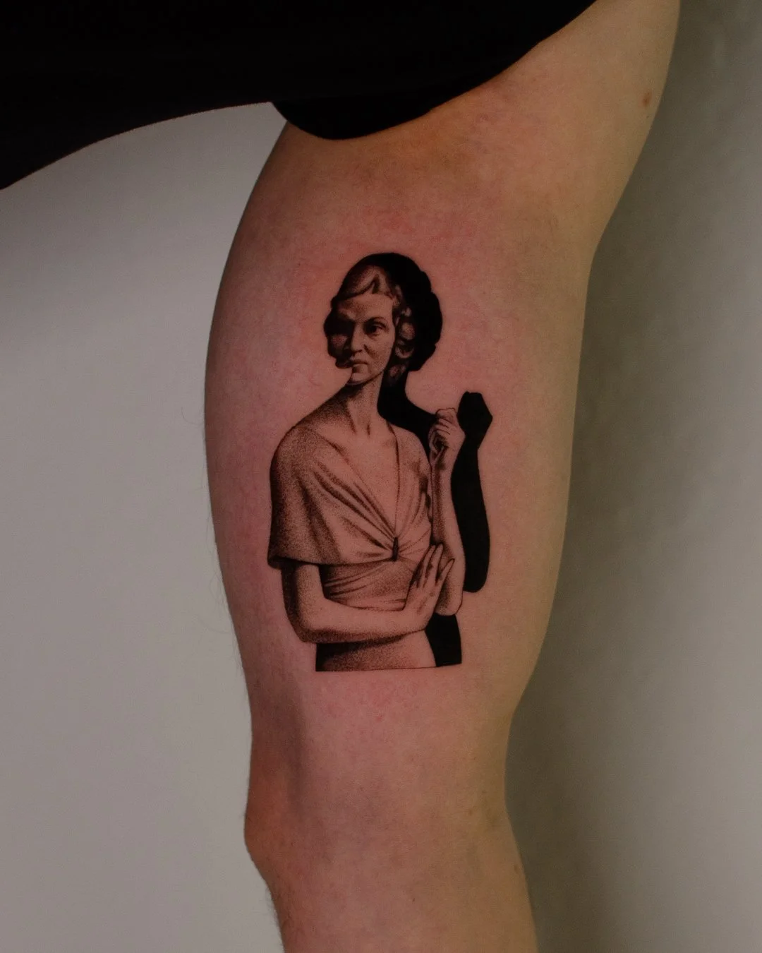 Tattoo of a vintage woman portrait on the upper arm.