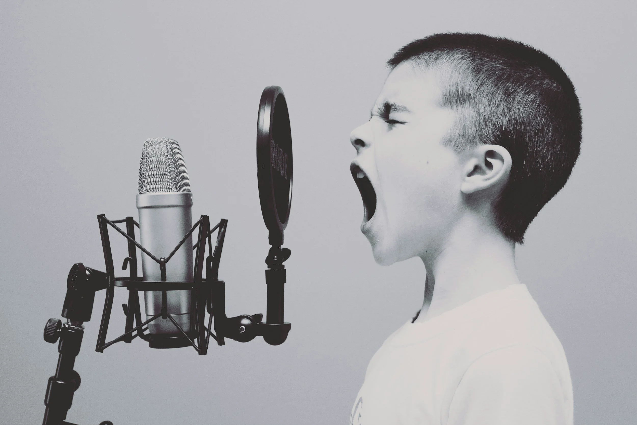 Child screaming into a studio microphone, representing survivors finding their voice after abuse