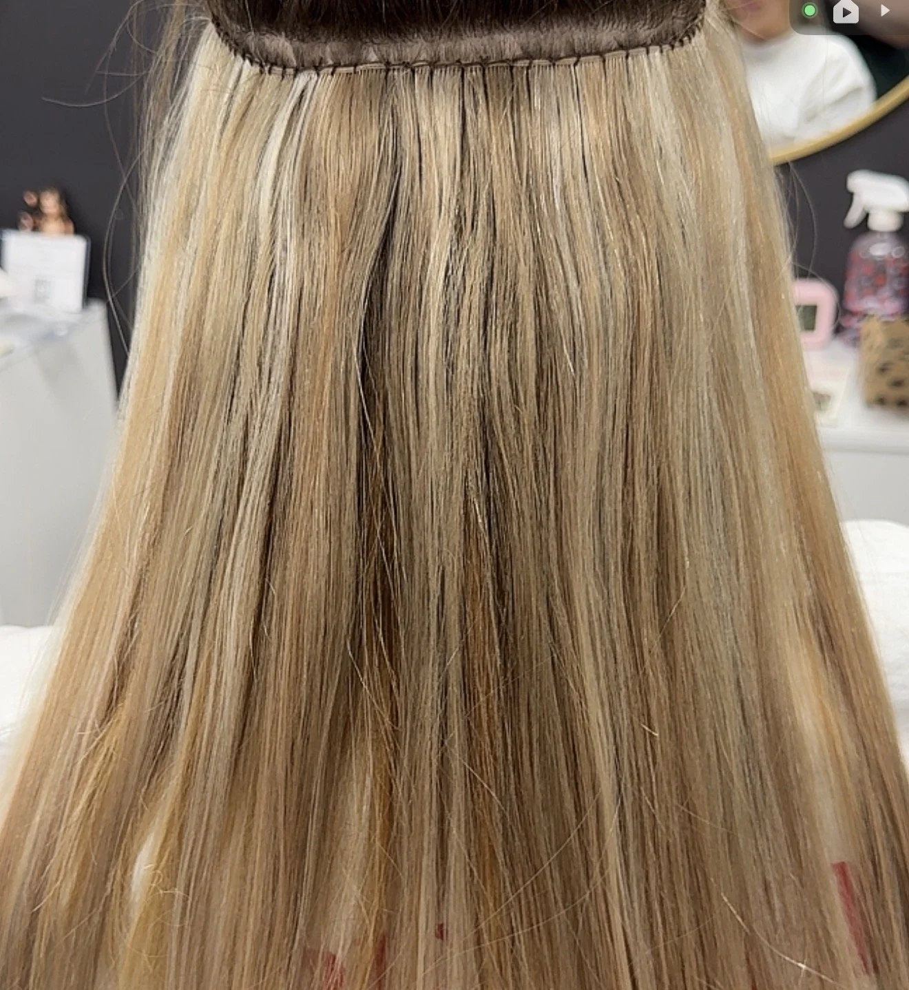 Close-up of a person's long, straight, blonde hair parted at the top.