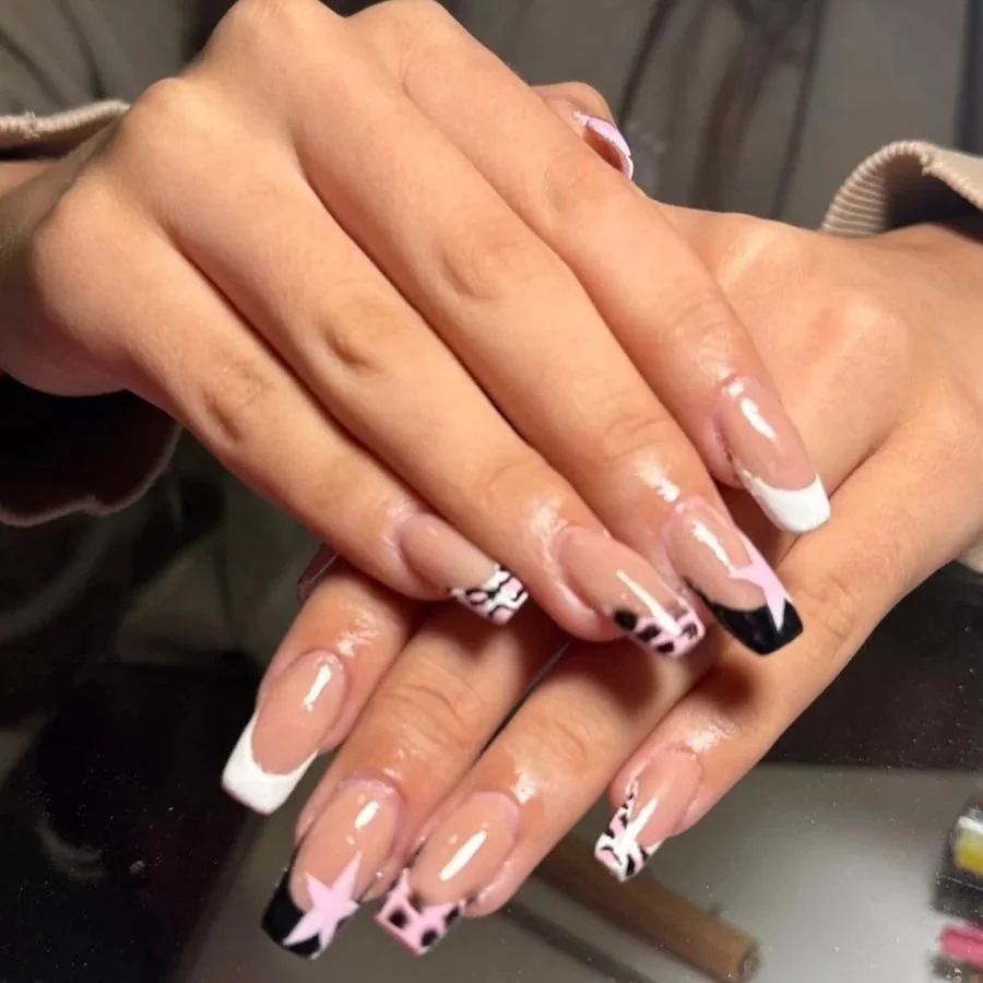 Uñas esmaltadas con diseño de animal print en tonos rosas, blancos y negros.