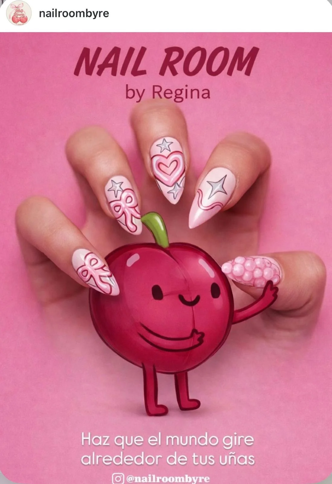 Manicura con uñas decoradas con corazones, estrellas y lazo, manos alrededor de un dibujo de una cereza con rostro y brazos, fondo rosa con texto en español que dice 'Haz que el mundo gire alrededor de tus uñas' y nombre de Instagram @nailroombyre.
