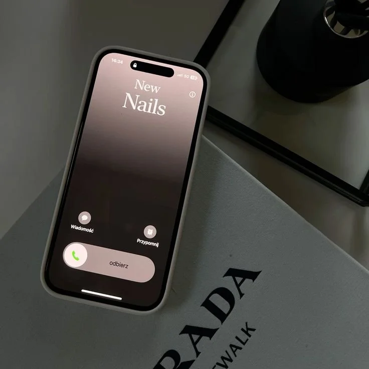 Pantalla de un teléfono móvil con una llamada entrante a un contacto llamado "New Nails" y el botón para aceptar la llamada.