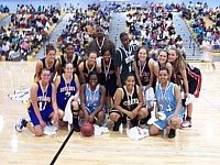 A group of young basketball players and their coach on a basketball court after a game or practice.