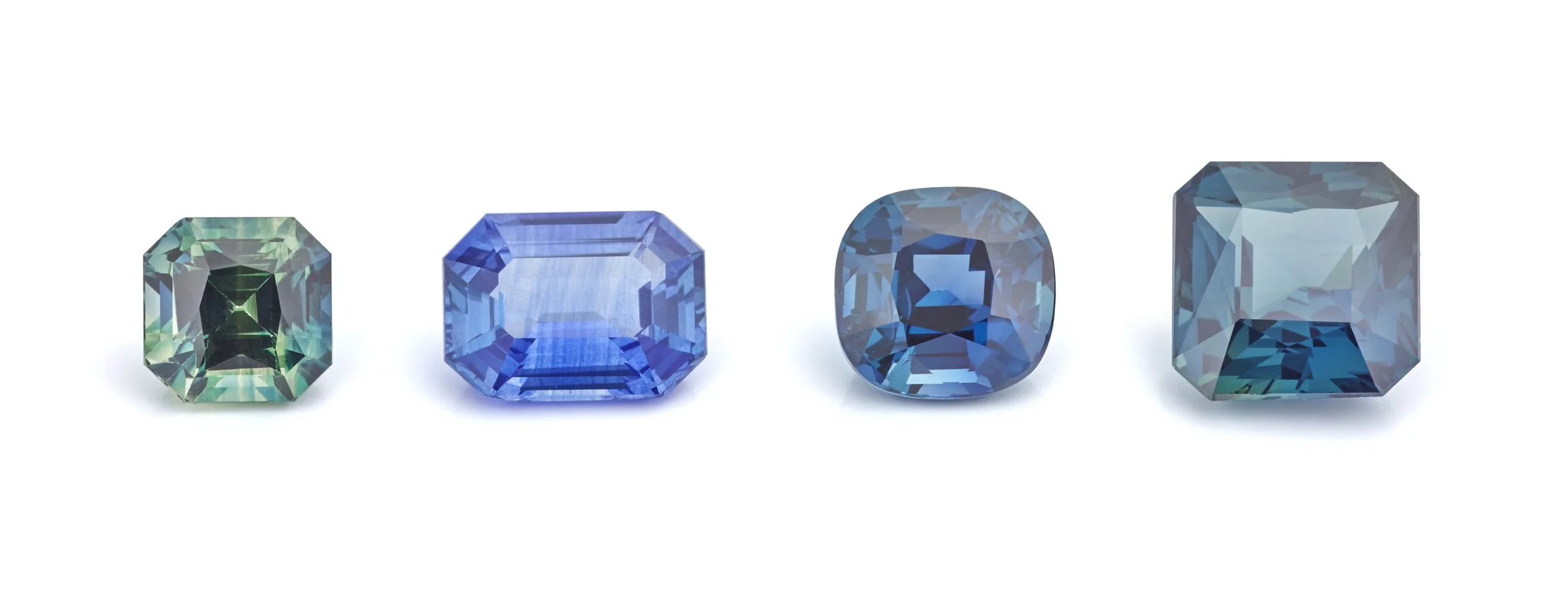green, blue and teal faceted sapphires on a white background