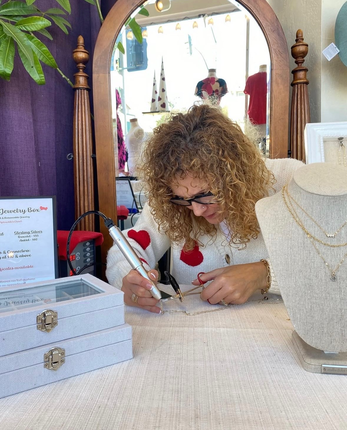 Amy, the owner of Amy's Jewelry Box working on a unique necklace for a customer.