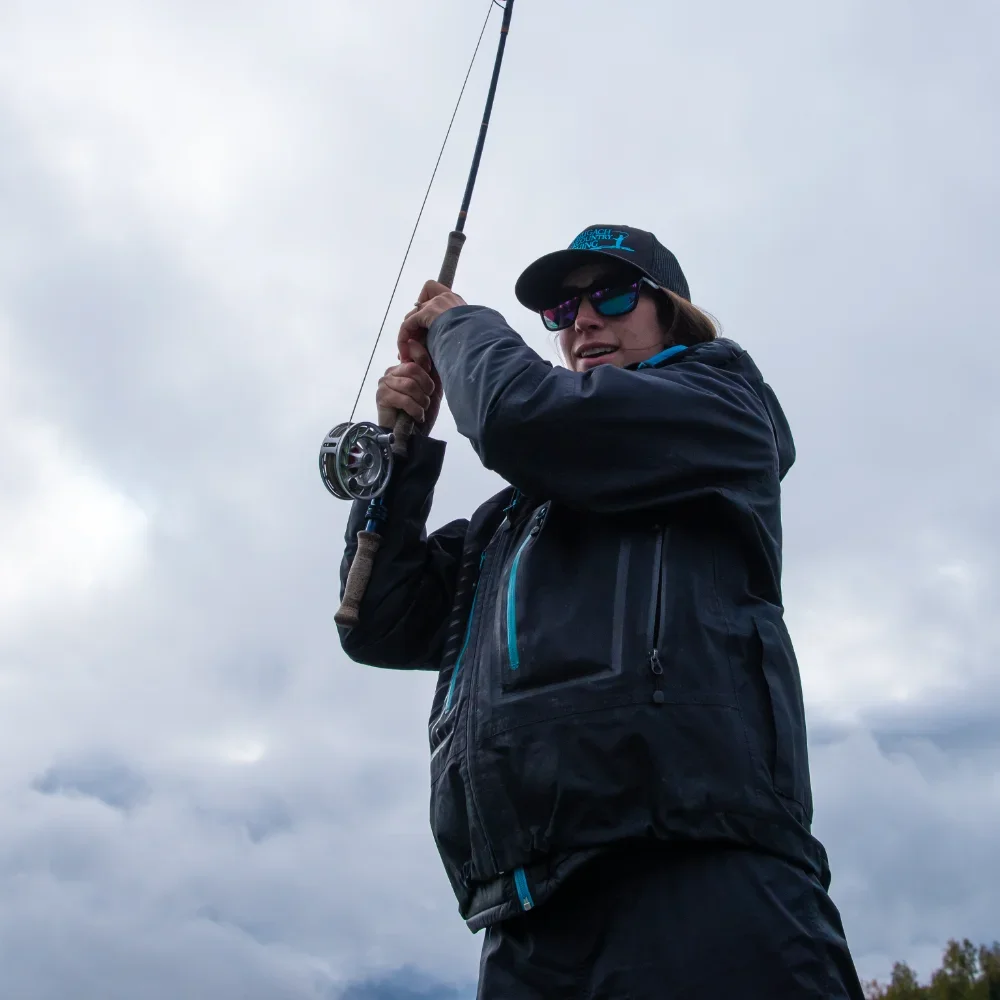 woman-casting-fly-rod-overhead-against-cloudy-sky.webp