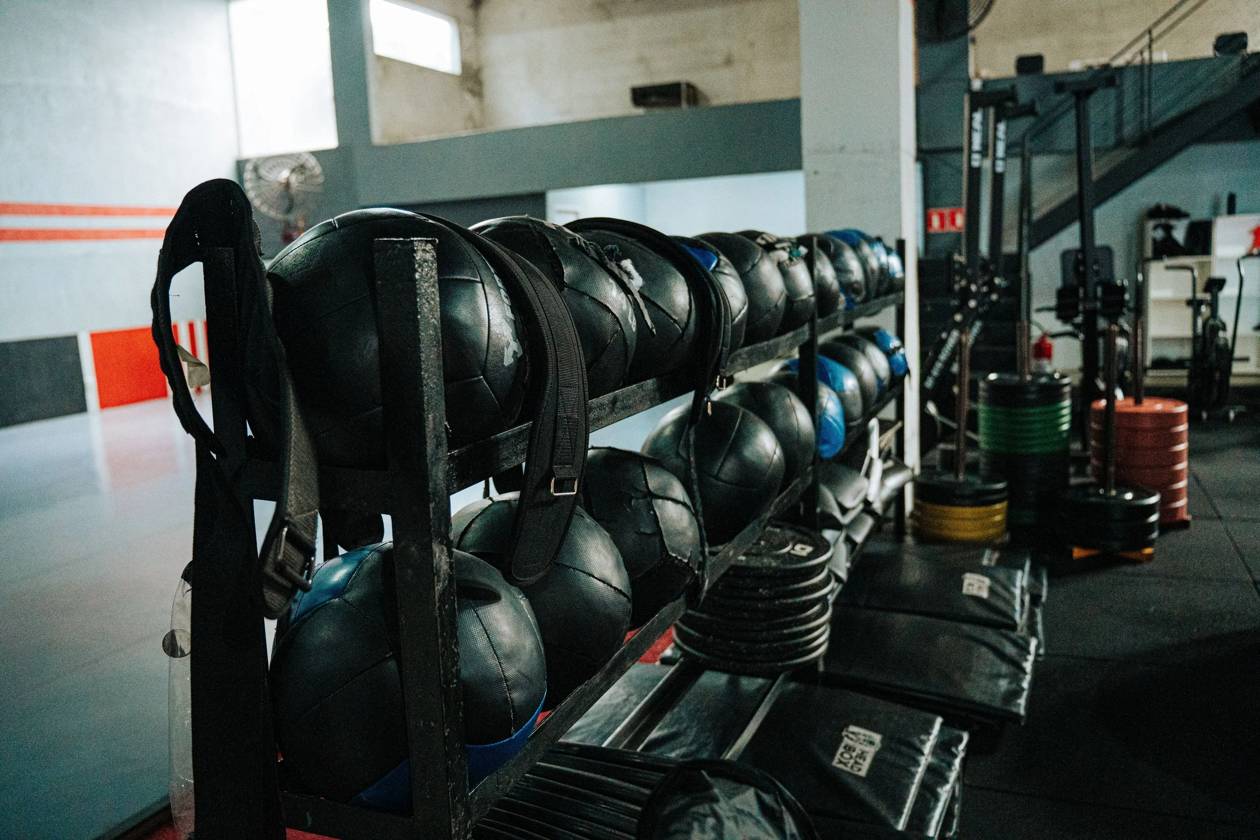 Shelf of black medicine balls in a gym.
