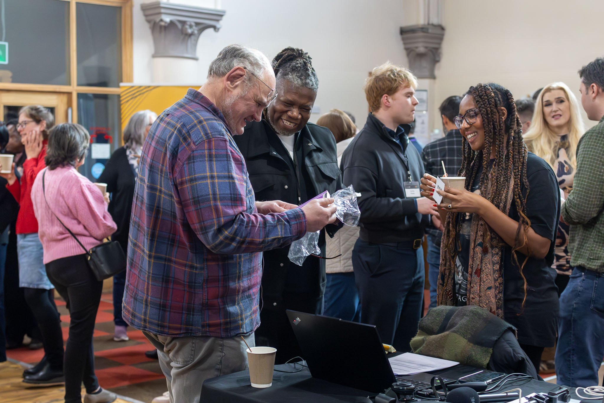 Delegates at an event interacting and smiling.