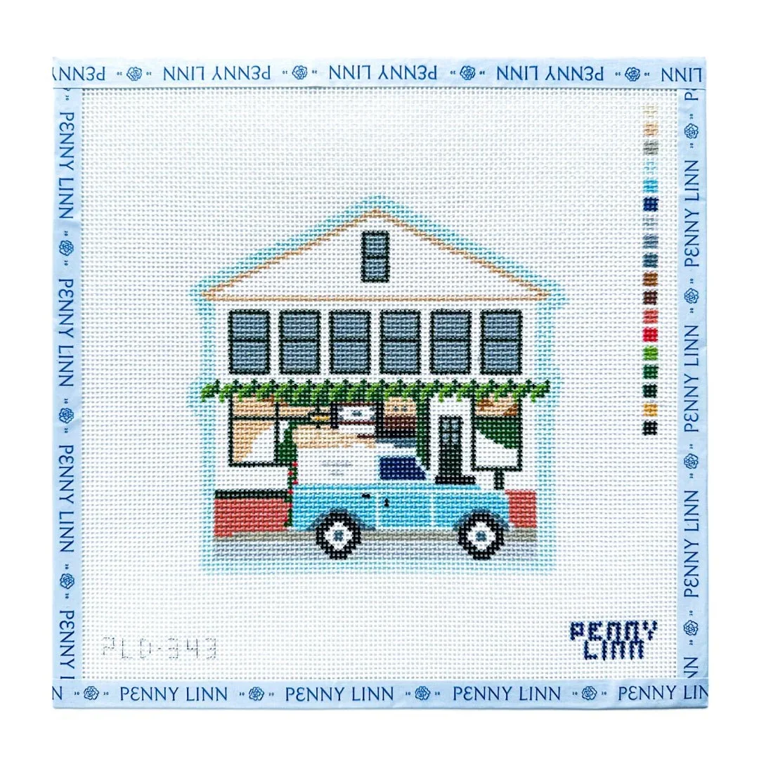 Cross-stitch embroidery of a blue house with a car in front, decorated with green garland on the porch, surrounded by a Penny Linn border and color key on the side.