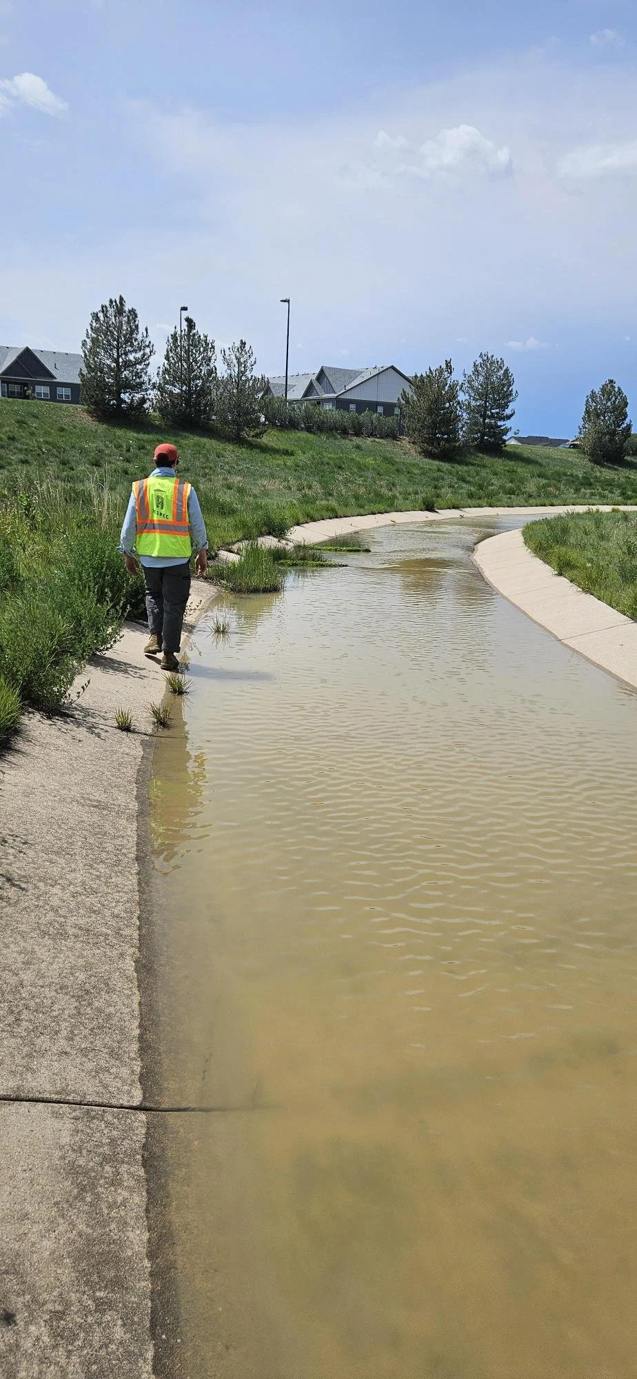 Water scientist walking along a stormwater ditch in El Paso County Colorado