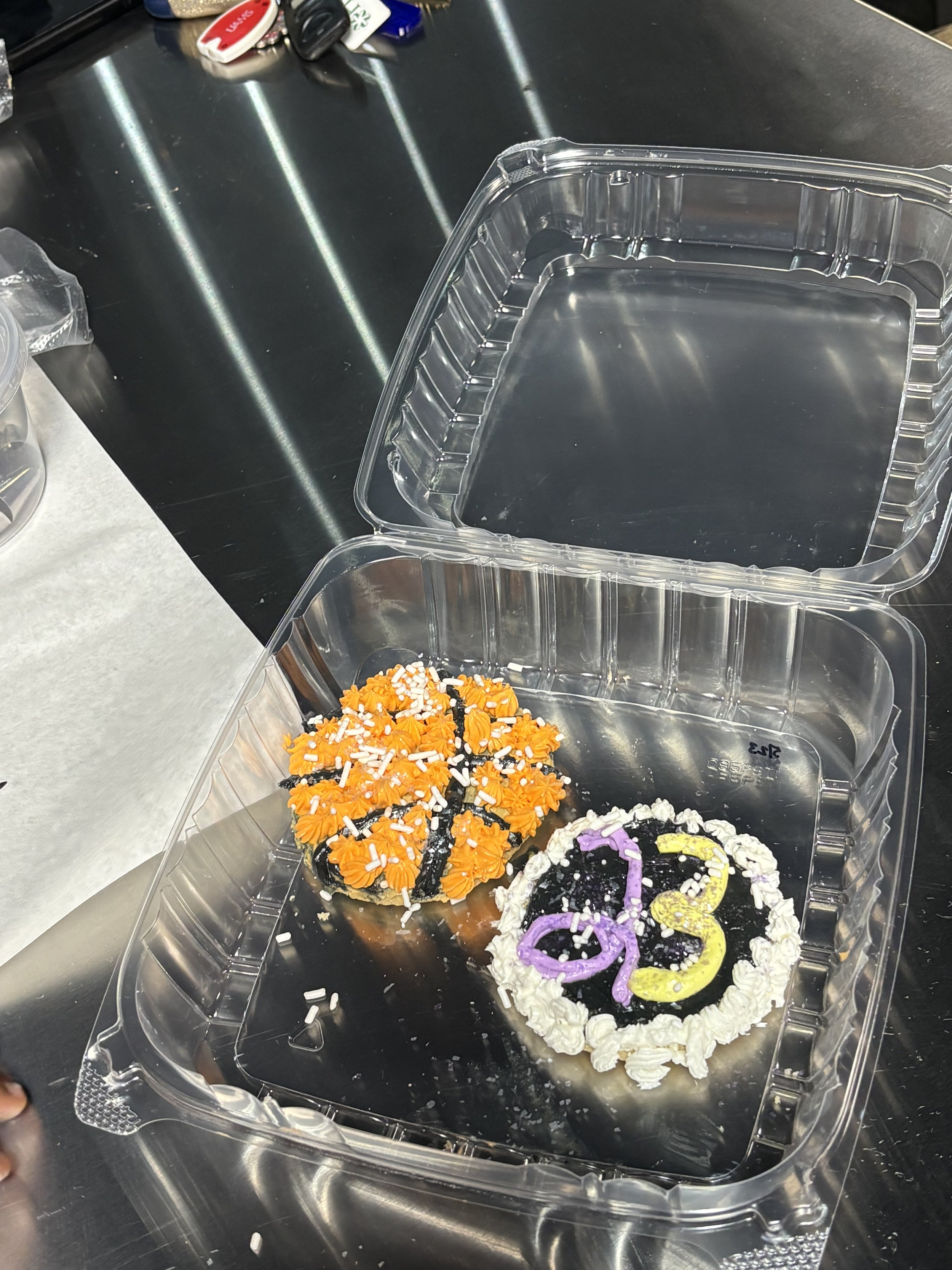 Halloween-themed decorated cookies inside a clear plastic container, with the number '2023' written on the cookies in colorful icing.