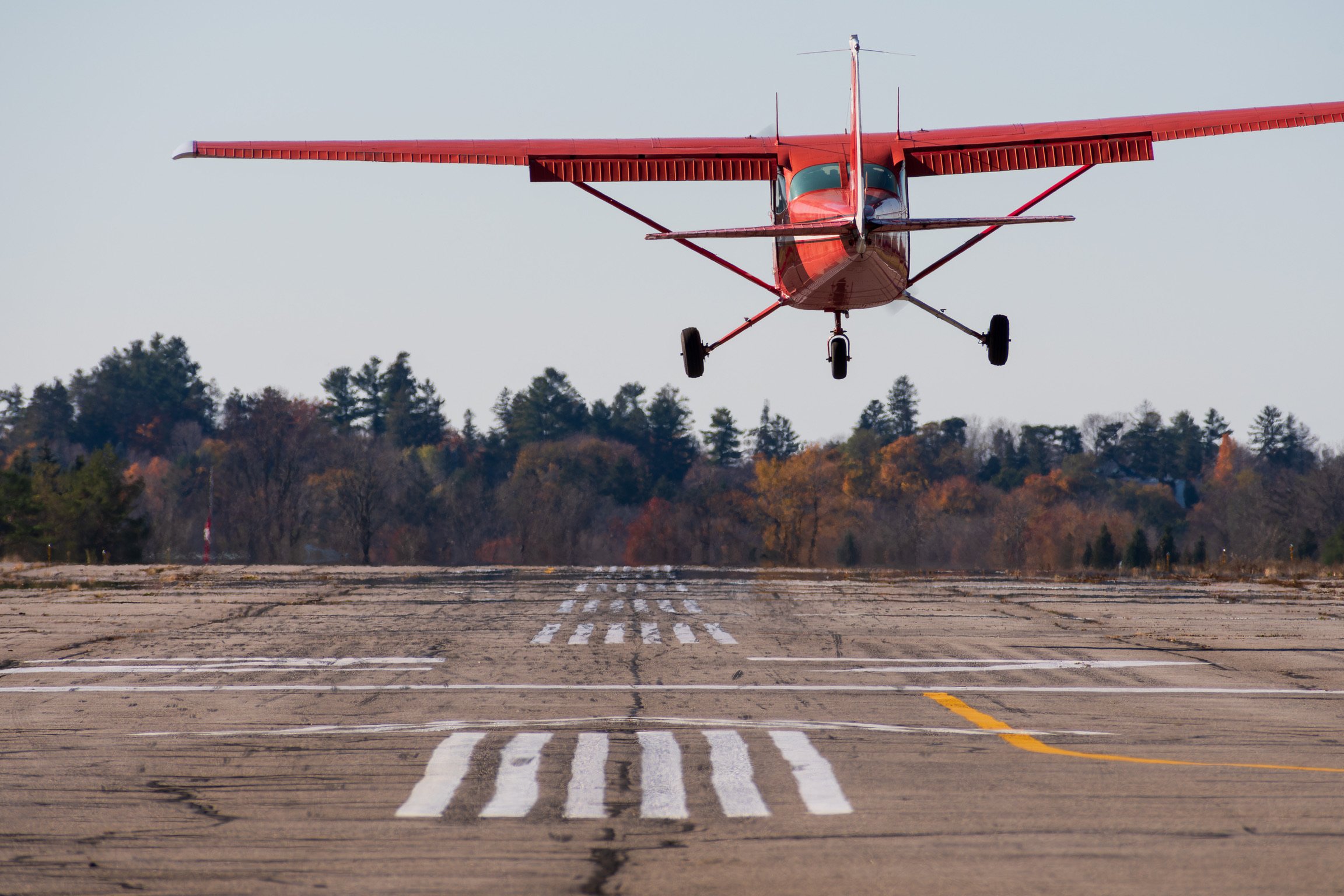 Scenic landscape of mountains, a lake, and rolling green hills beneath an overcast sky.