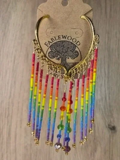 Colorful beaded ear cuffs with a gold setting, attached to a Fablewood tag.