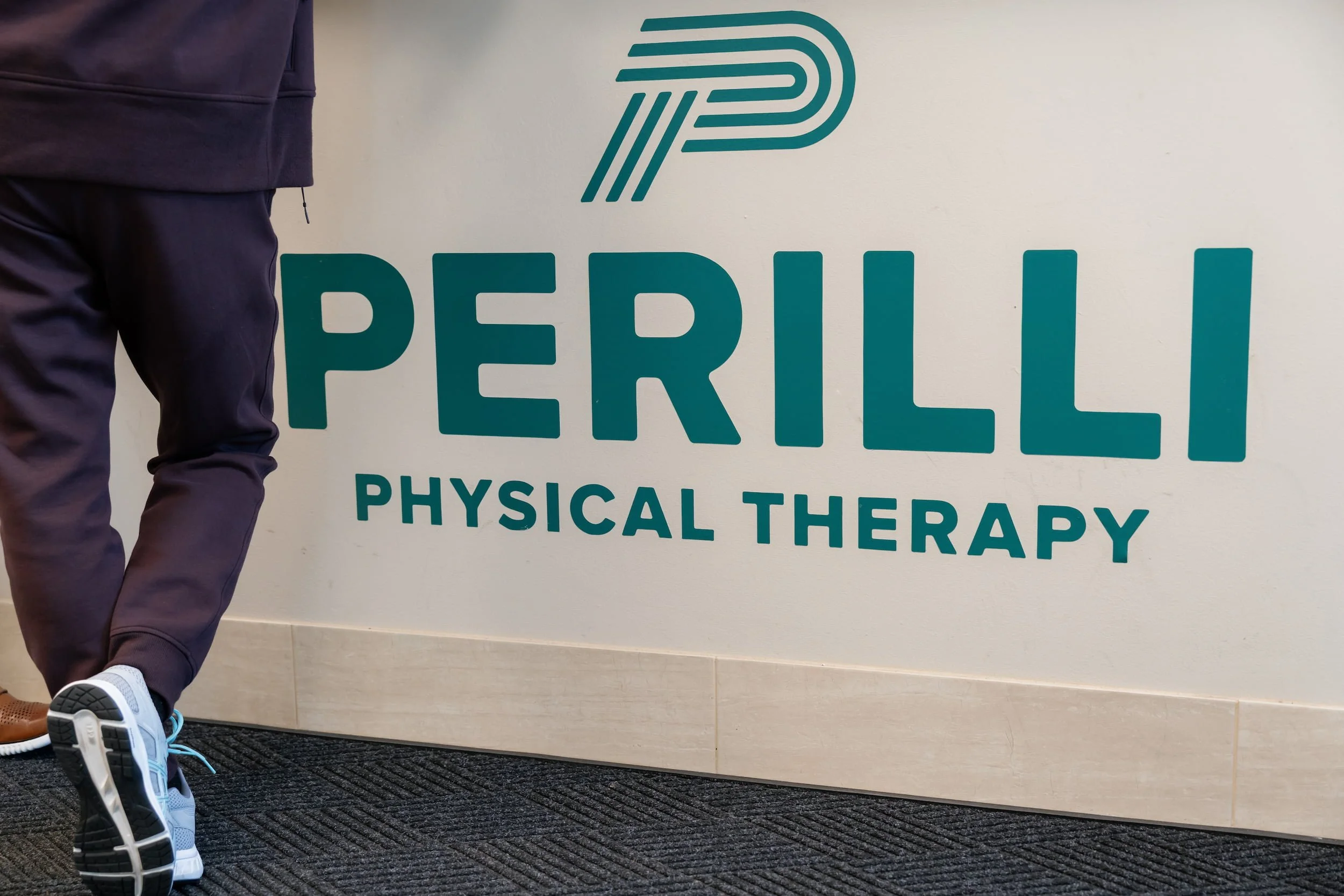Person standing at front desk of physical therapy office