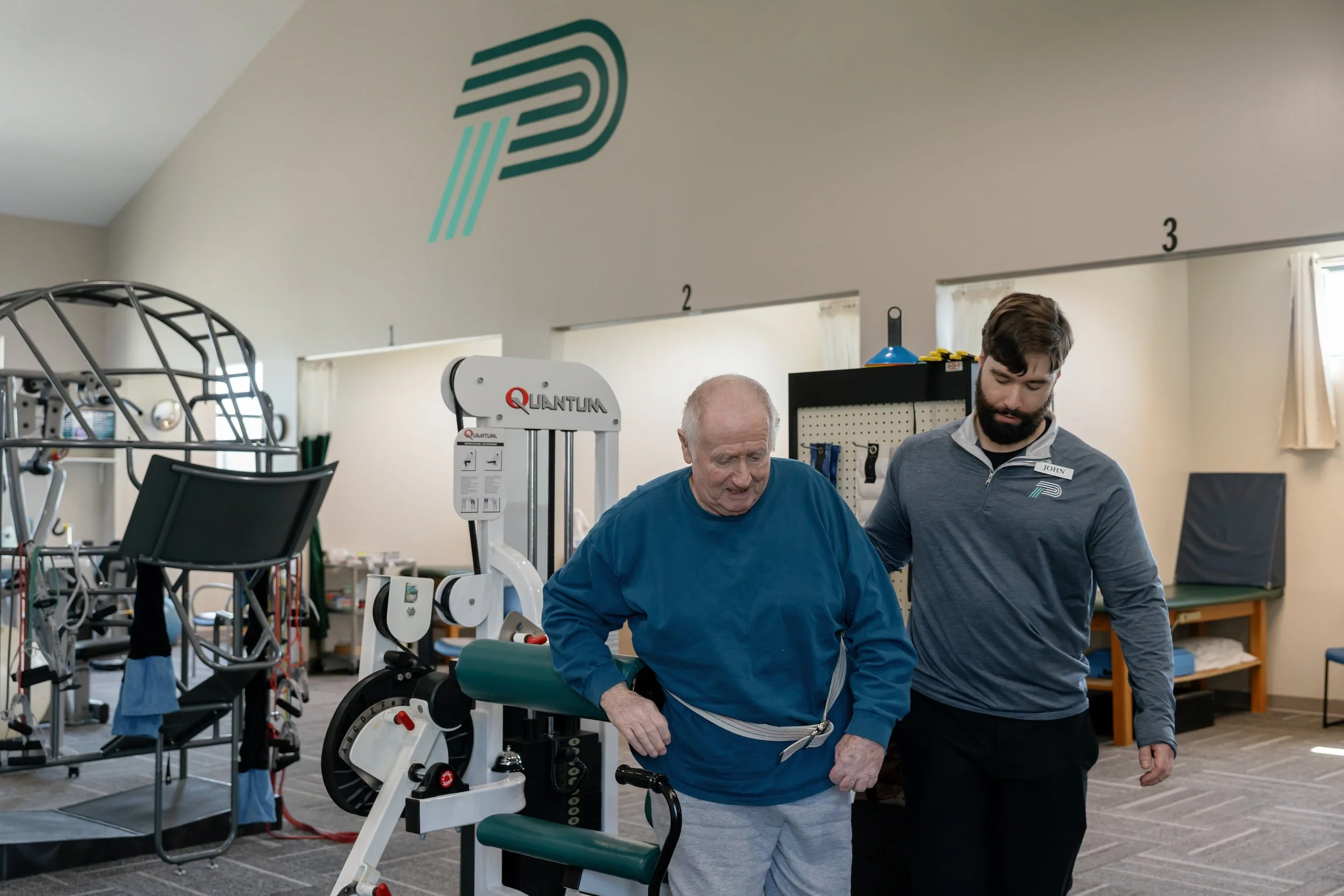 Older man being assisted by physical therapist through a workout